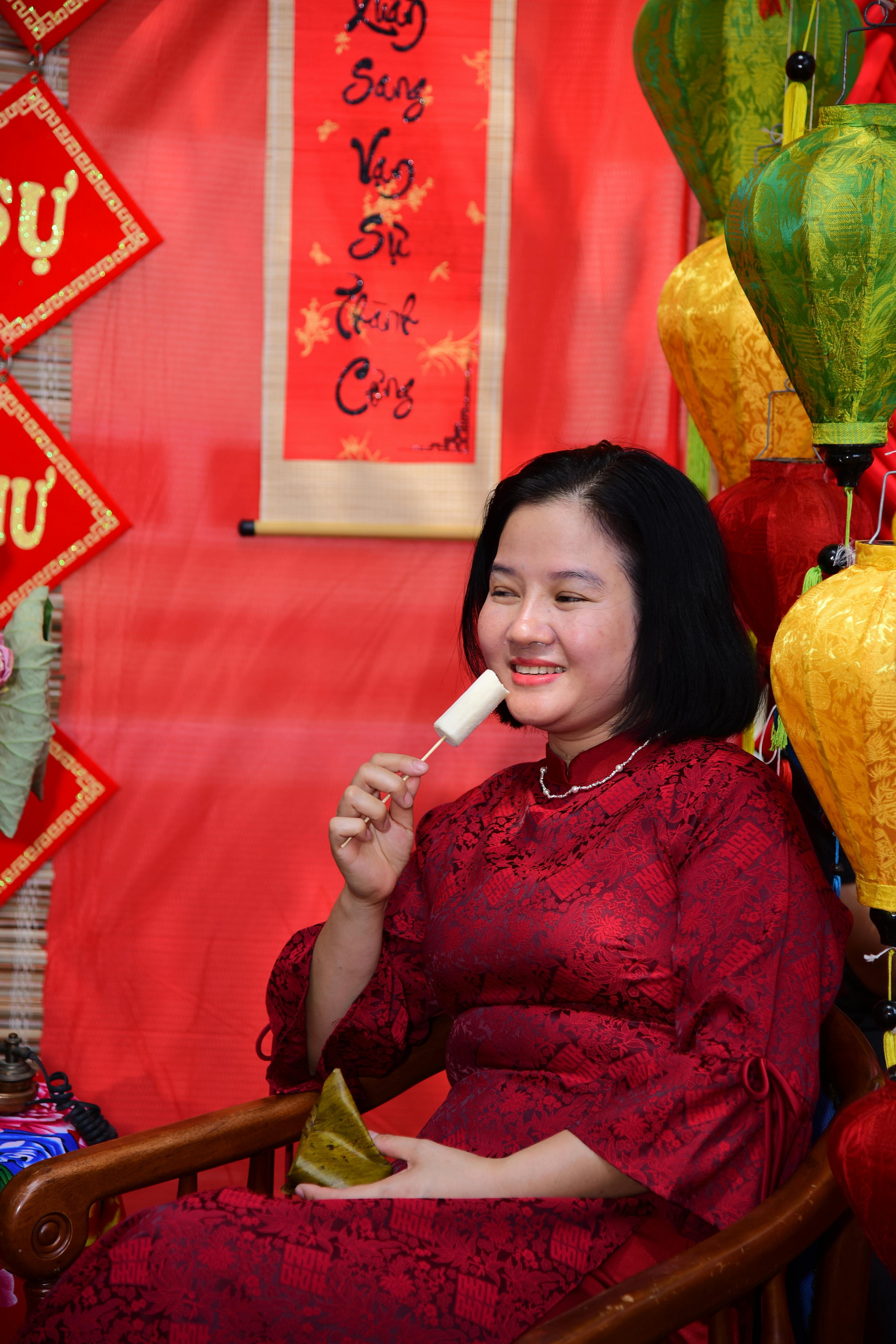 Ilmainen Hymyilevä nainen punaisessa mekossa nauttii juhlallisuuksista värikkäiden lyhtyjen ja koristeiden keskellä. Kuvapankkikuva