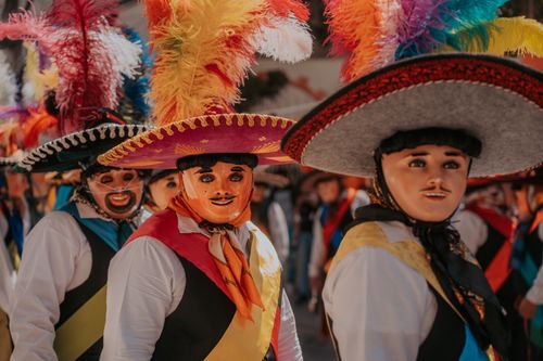 Free Vibrant traditional costume-clad dancers at a colorful Mexican carnival parade in Puebla. Stock Photo