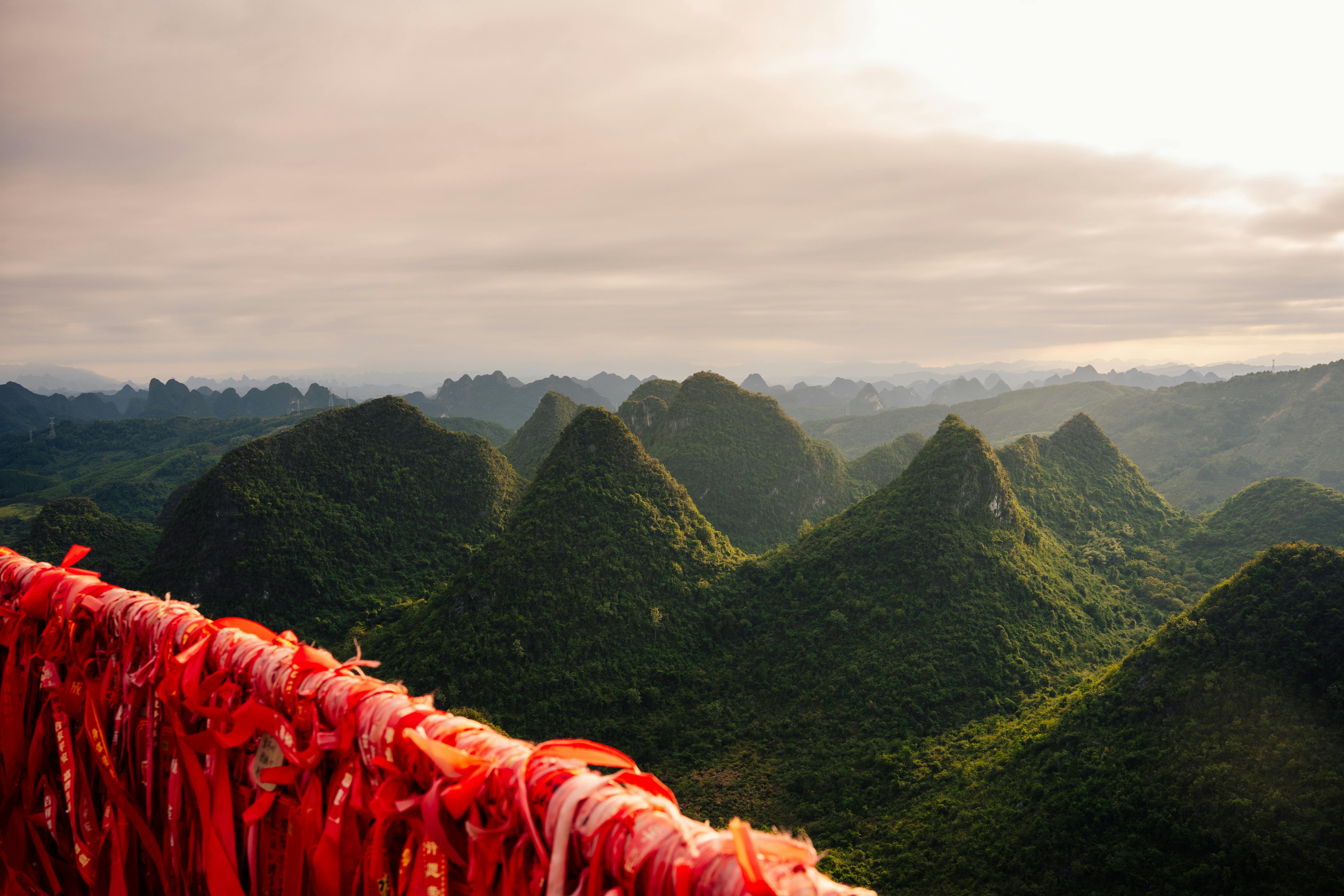 Ilmainen Henkeäsalpaava näkymä reheville karstivuorille Guilinissa, Guangxissa, Kiinassa. Punaiset nauhat luovat eloisan kontrastin. Kuvapankkikuva