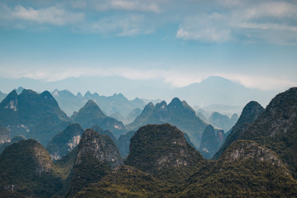 A panoramic view of the iconic karst mountains under a blue sky in Guilin, China.