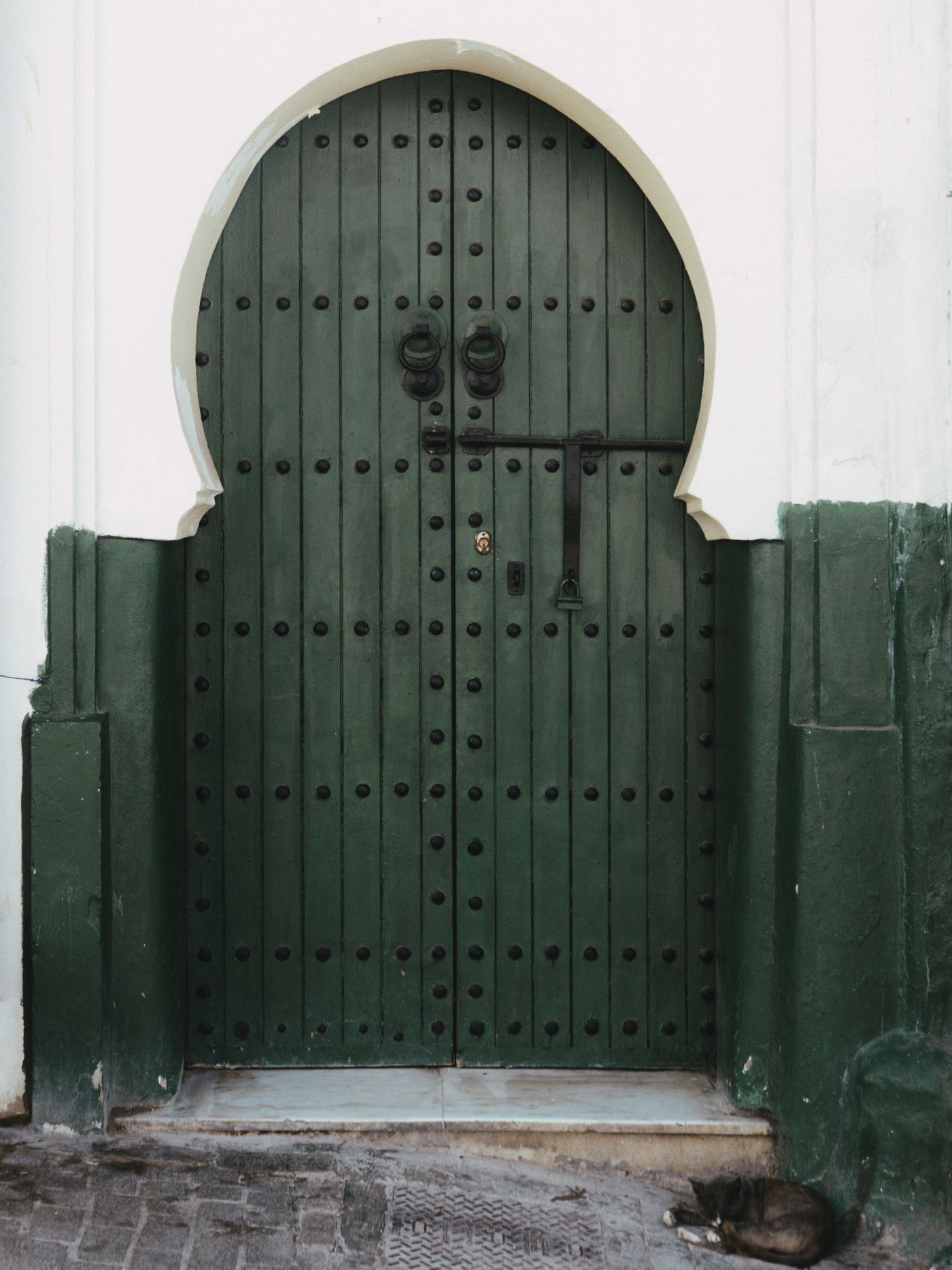 Traditional arched doorway and sleeping cat in Tangier medina, Morocco