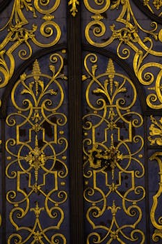 Close-up of an ornate gold baroque gate with intricate ironwork patterns, elegant and artistic.
