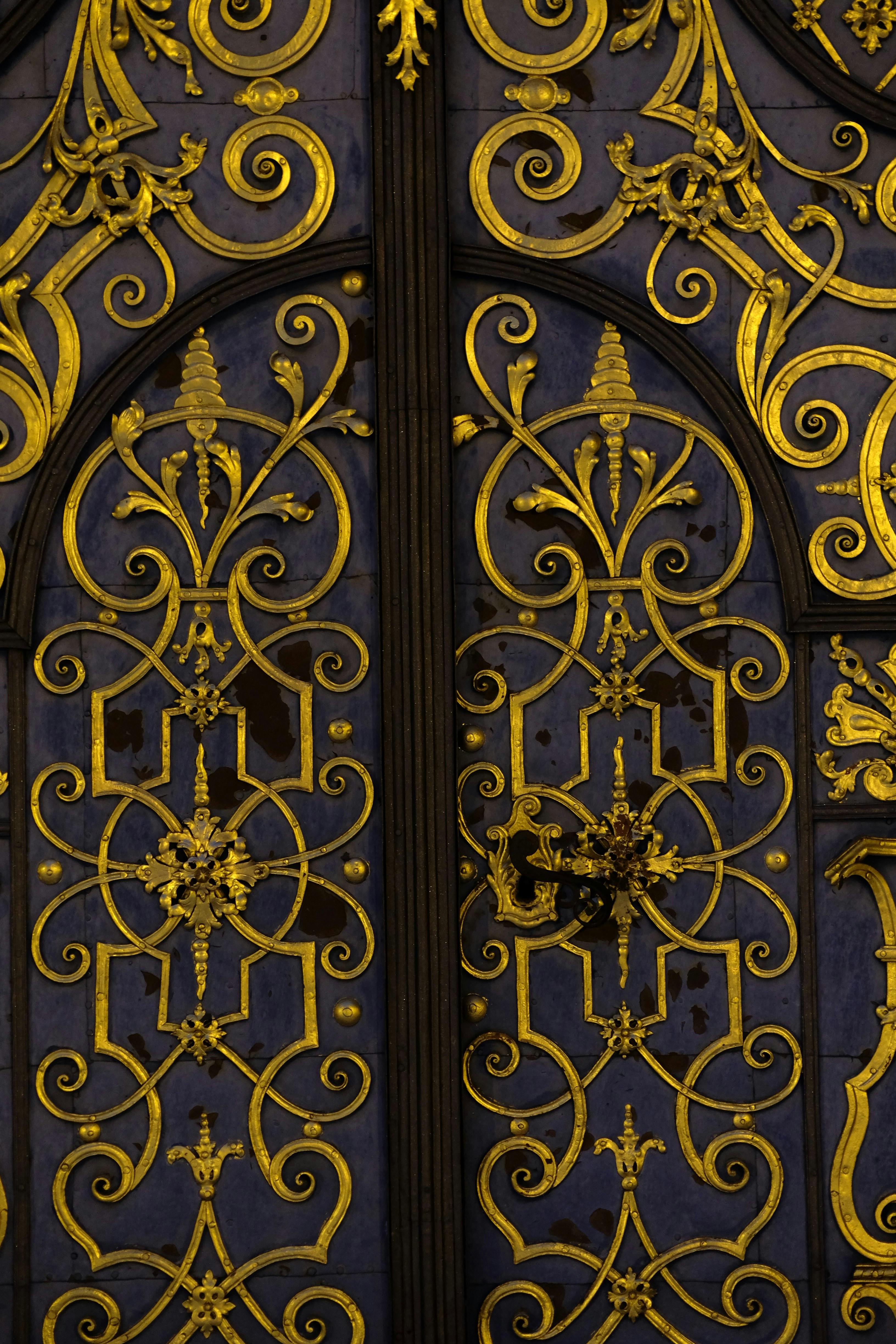 Gratis Primer plano de una puerta barroca dorada adornada con intrincados patrones de herrería, elegante y artística. Foto de stock