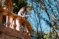 Woman in Pink Dress on Rustic Balcony Outdoors