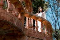 Woman in Traditional Dress on Brick Balcony