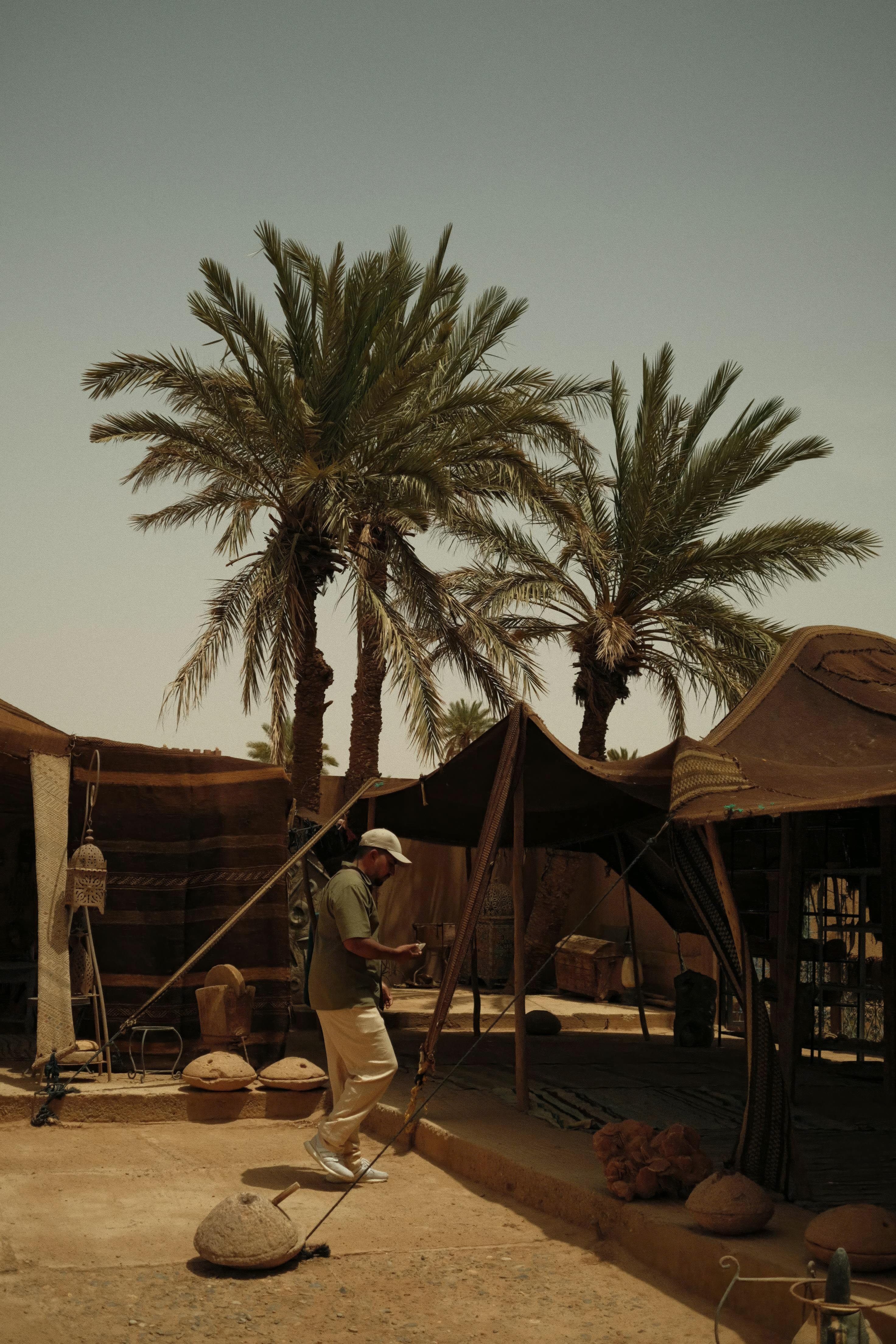 Ilmainen Nomadi telttojen ja palmujen keskellä Merzougan autiomaassa vangitsemassa Marokon olemuksen. Kuvapankkikuva