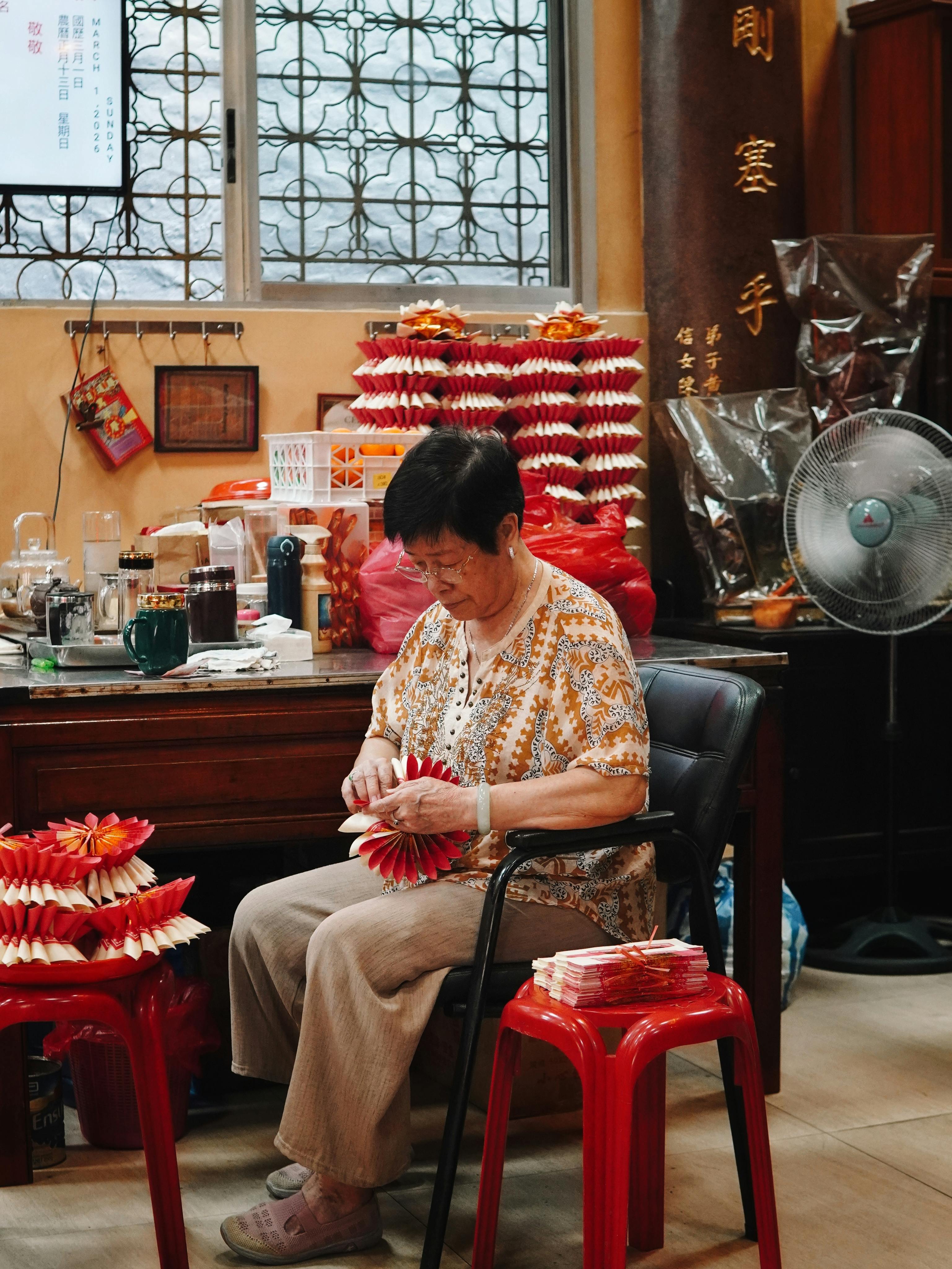 Ilmainen Vanhempi nainen luo paperiaskarteluja perinteisessä ympäristössä. Kuvapankkikuva