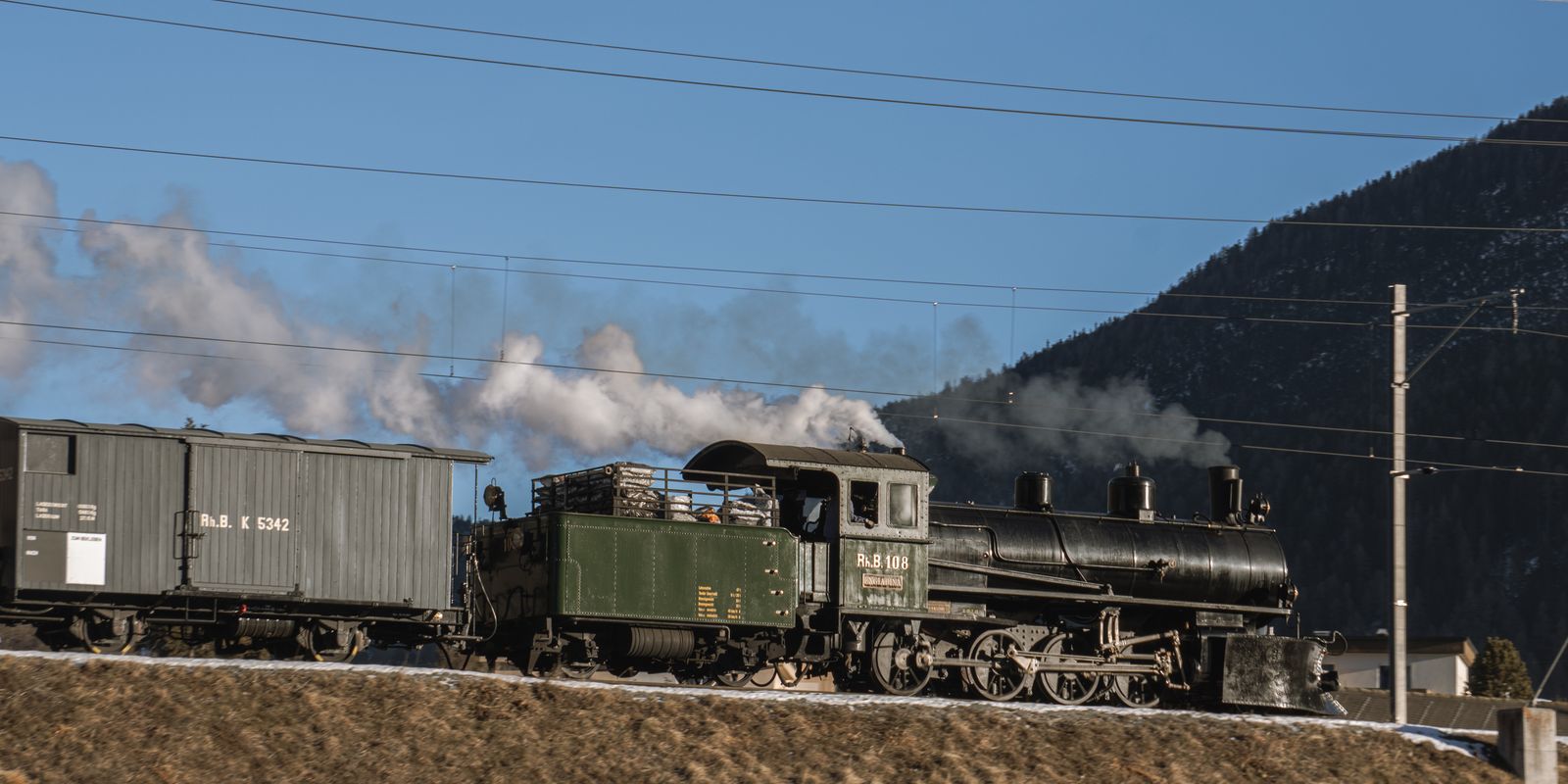 Vintage steam locomotive traveling through a mountain landscape