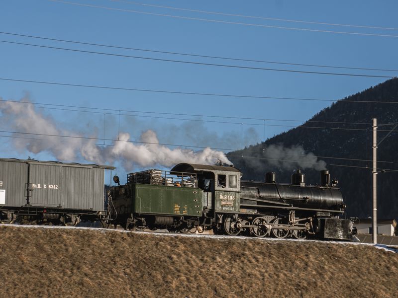 Vintage steam locomotive traveling through a mountain landscape