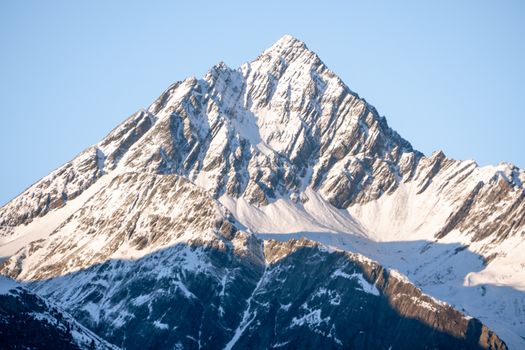 Breathtaking view of a snow-capped mountain peak against a clear blue sky.