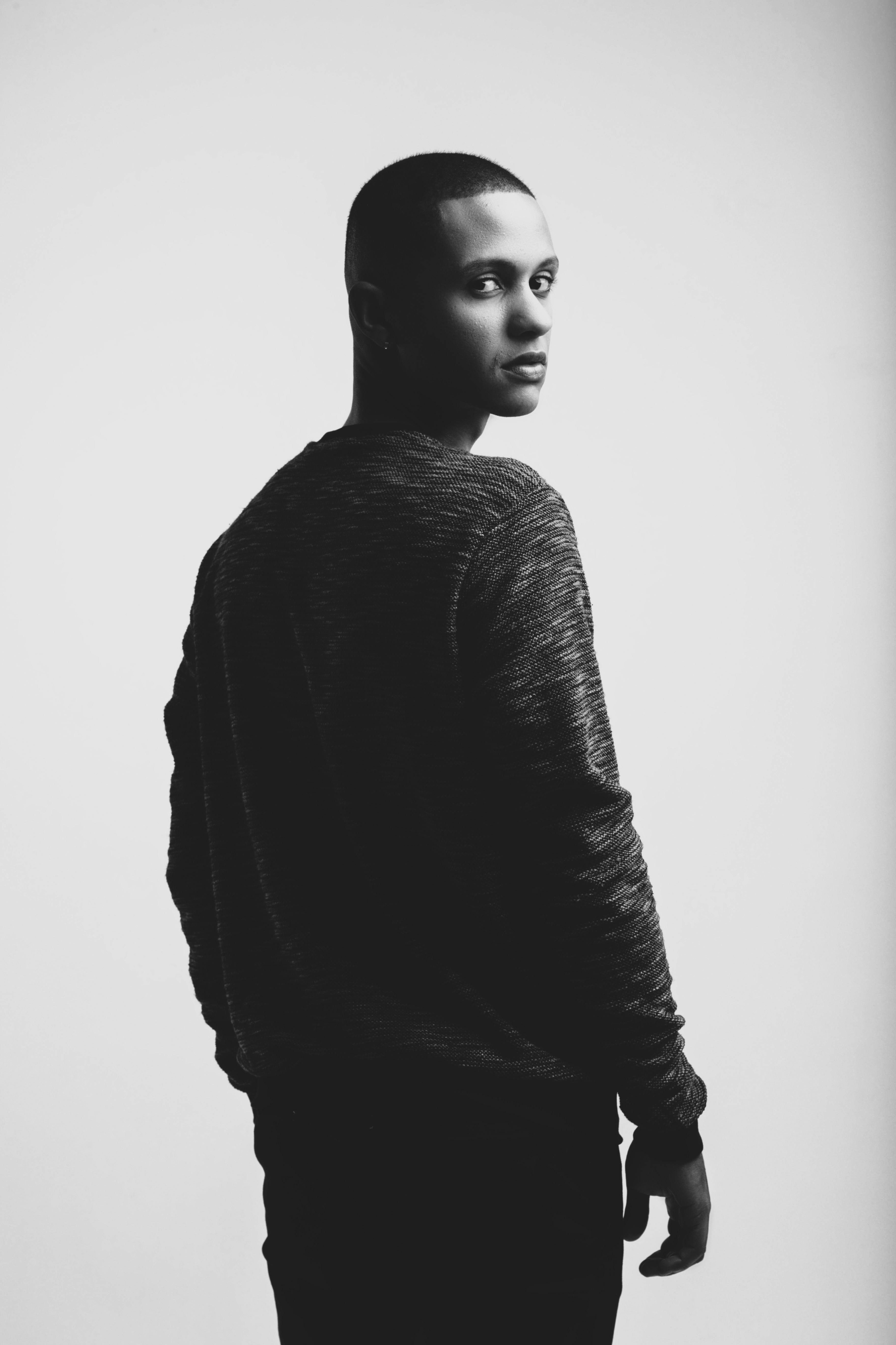 Bezpłatne Artystyczny czarno-biały portret mężczyzny w zamyślonej pozie. Zdjęcie z galerii