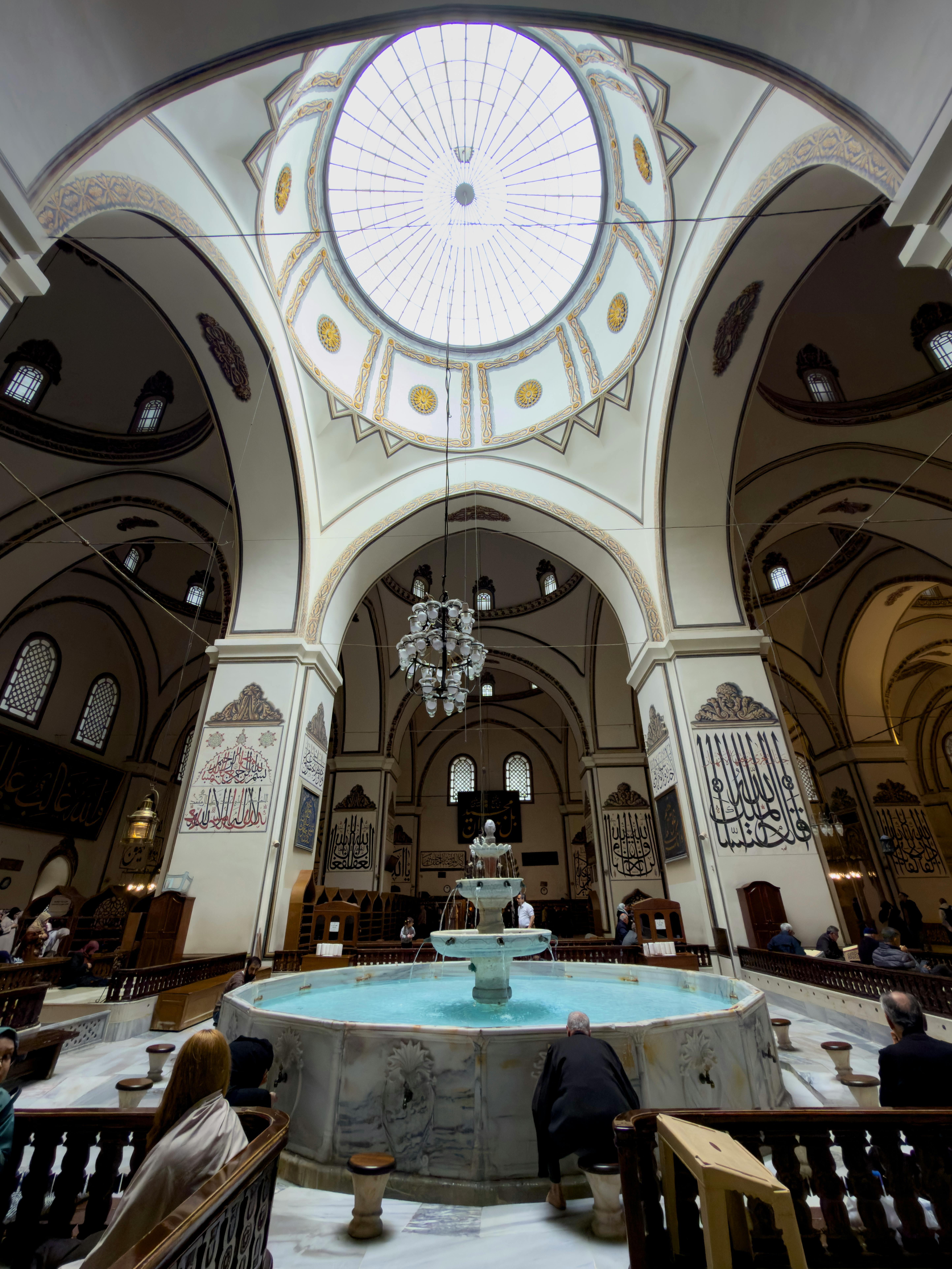 ฟรี ภาพมุมมองที่สวยงามตระการตาของภายในมัสยิดอูลูคามิในเมืองบูร์ซา ที่มีโดมประดับประดาอย่างวิจิตรและน้ำพุหินอ่อน คลังภาพถ่าย