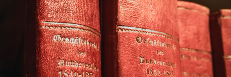 Red leather-bound parliamentary books from 19th century in Bern library, Switzerland.