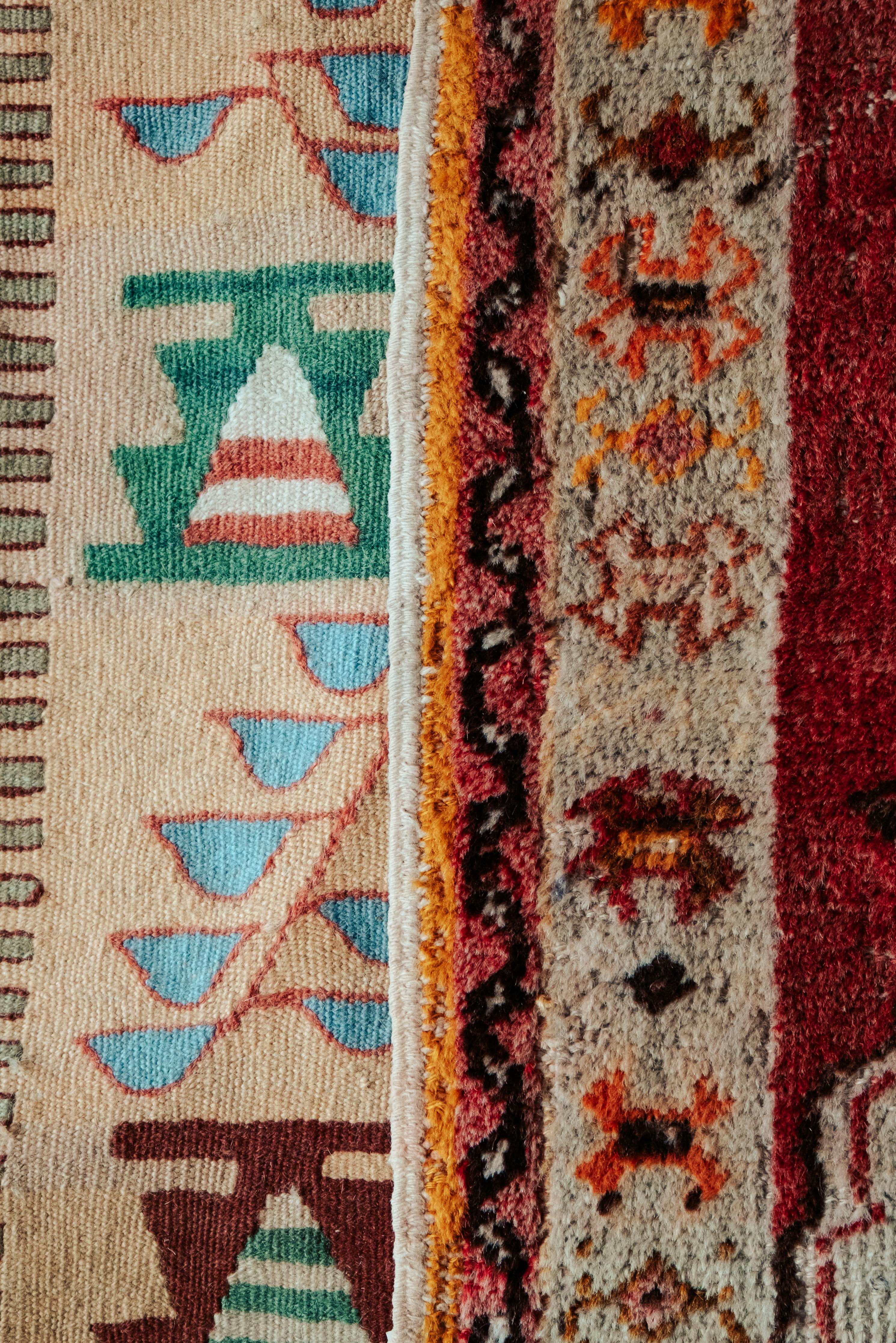 Ilmainen Lähikuva värikkäistä, kuviollisista turkkilaisista kilim-matoista, joissa on rikkaita tekstuureja ja kuoseja. Kuvapankkikuva