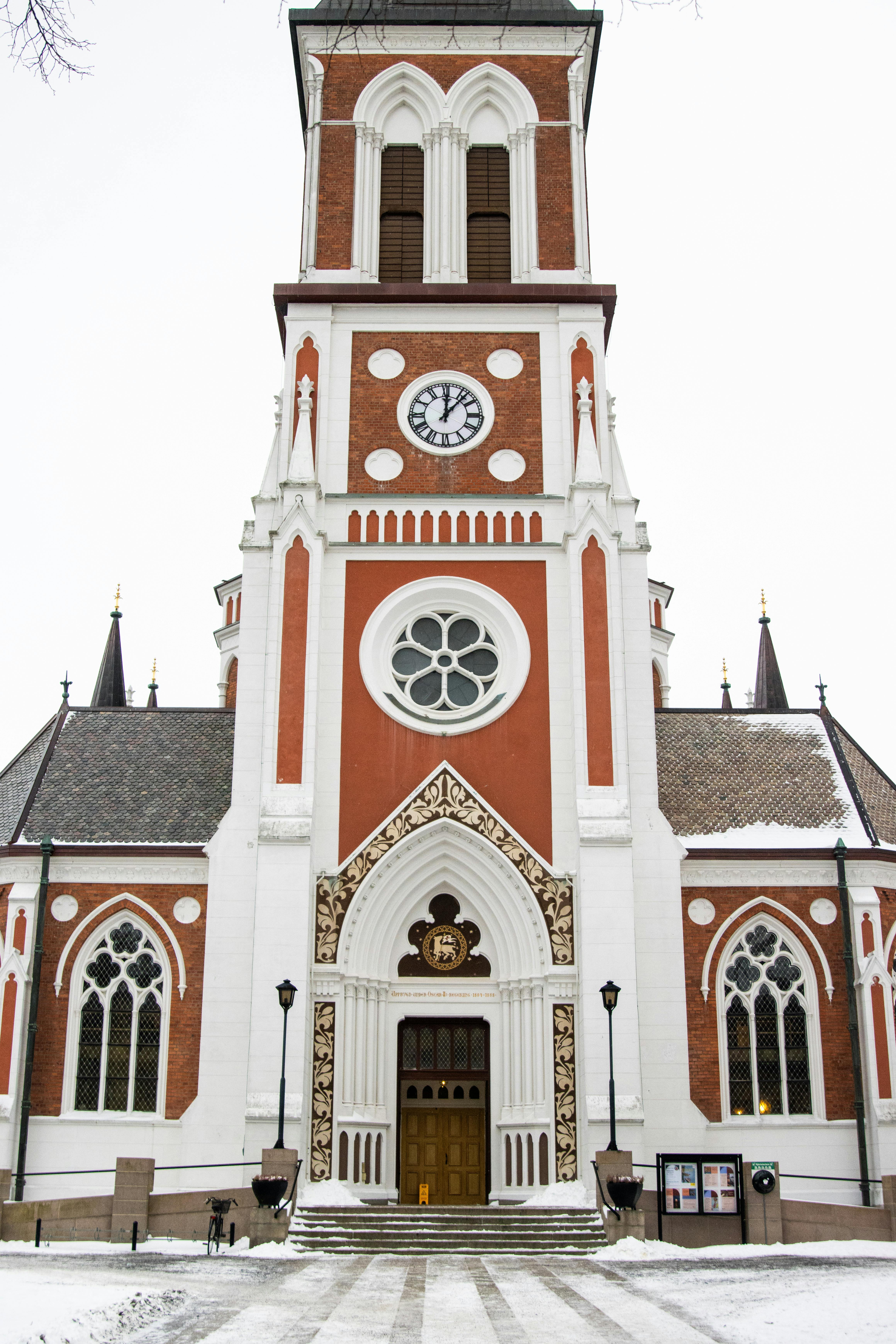 Ilmainen Majesteettinen punavalkoinen goottilainen kirkontorni lumisissa Jönköpingissä, Ruotsissa. Kuvapankkikuva