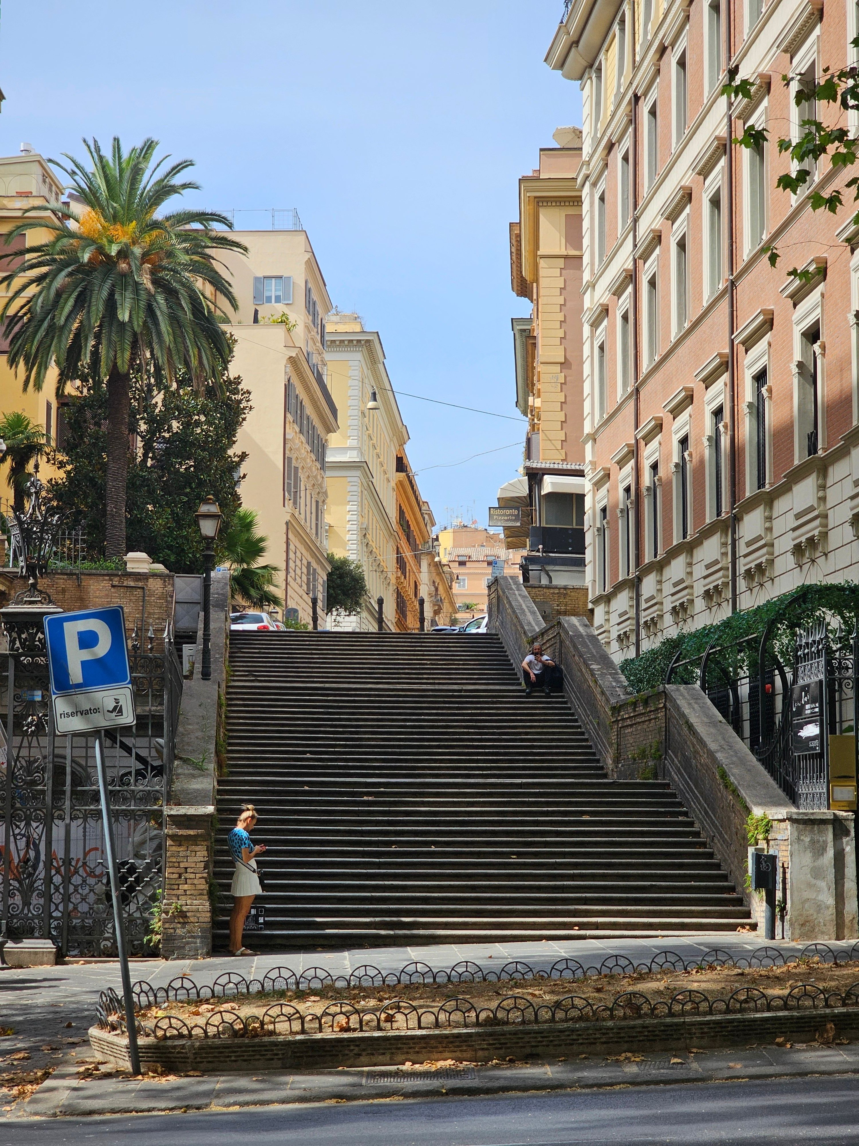 A picturesque view of a historic staircase surrounded by classic buildings in Rome, Italy, on a sunny day.