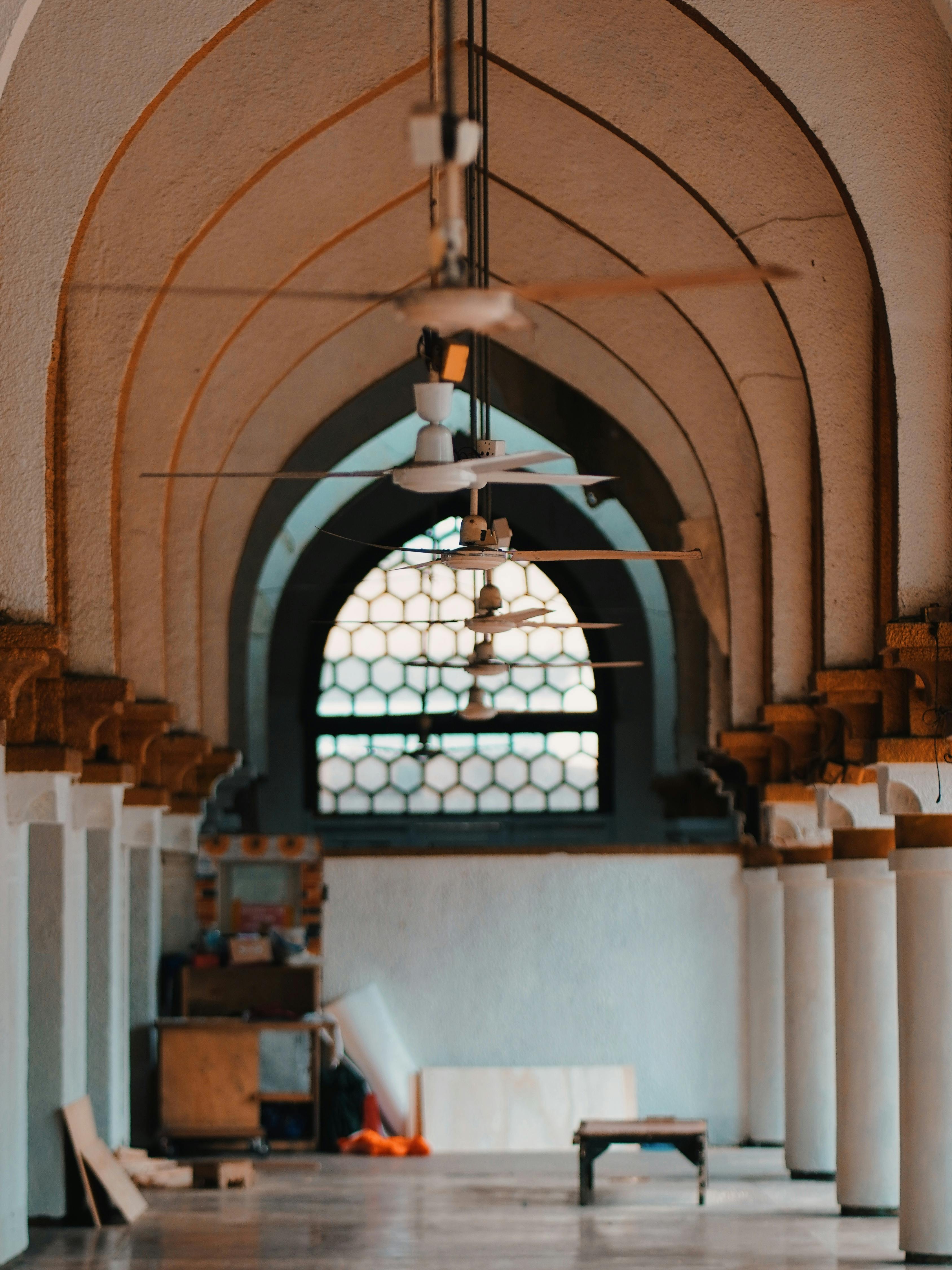 Ücretsiz Tavan vantilatörleri ve kemerli tasarımıyla mimari zarafeti vurgulayan, güzel bir kemerli koridor. Stok Fotoğraflar