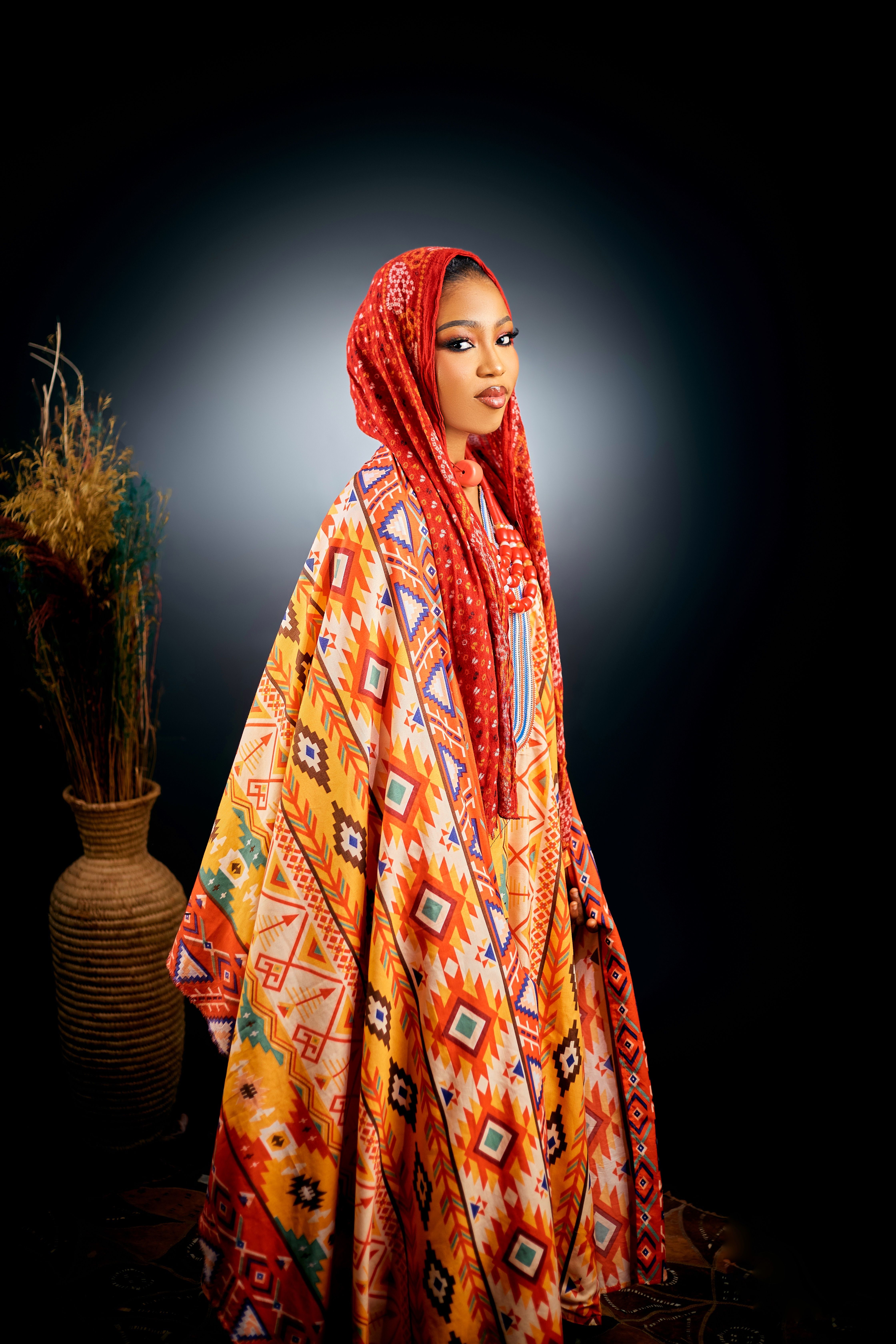 Portrait of a woman in colorful African dress and headscarf, vibrant and elegant.