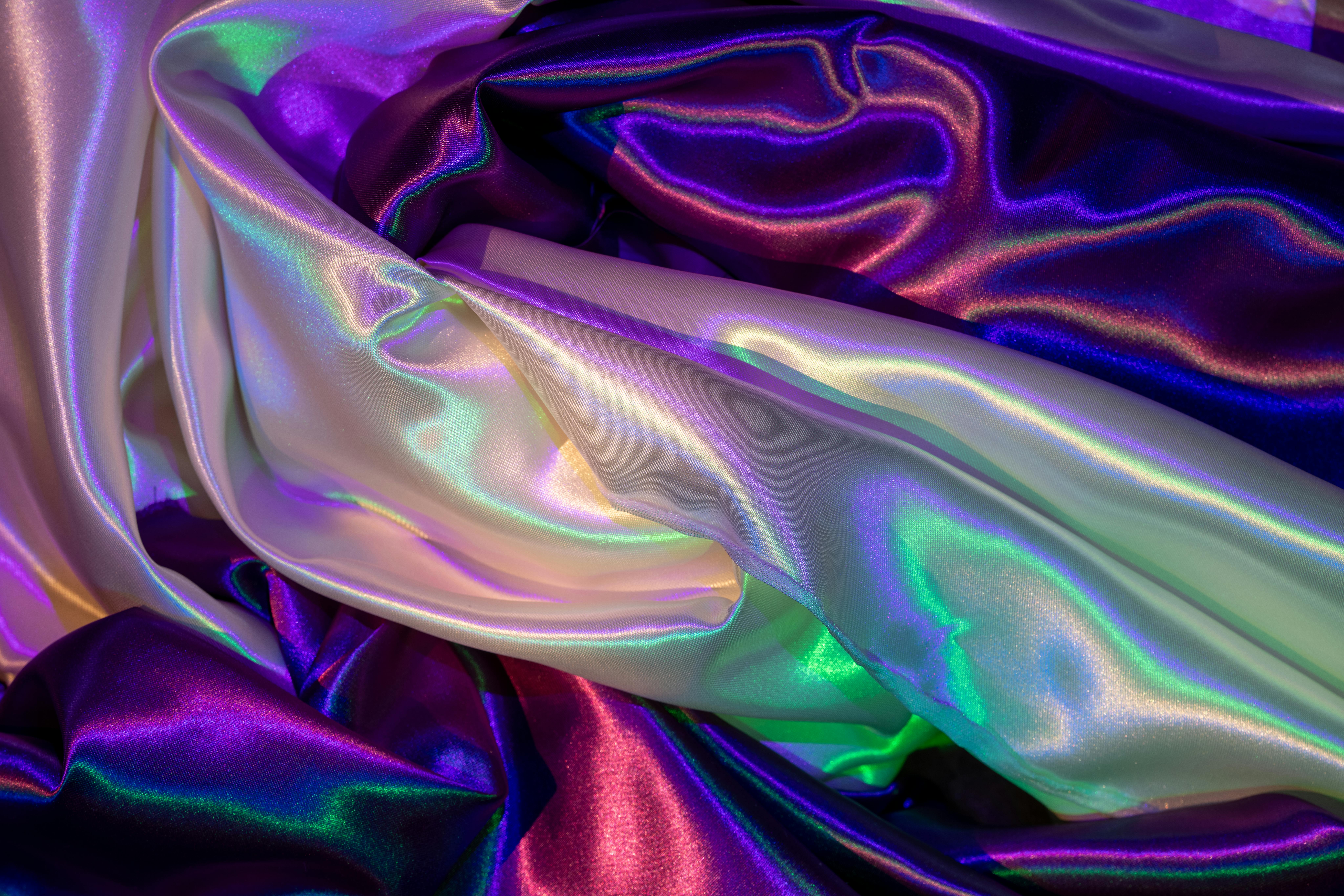 bezplatná Luxusní saténová látka s živým, barevným osvětlením vytváří umělecký abstraktní vzor. Základová fotografie