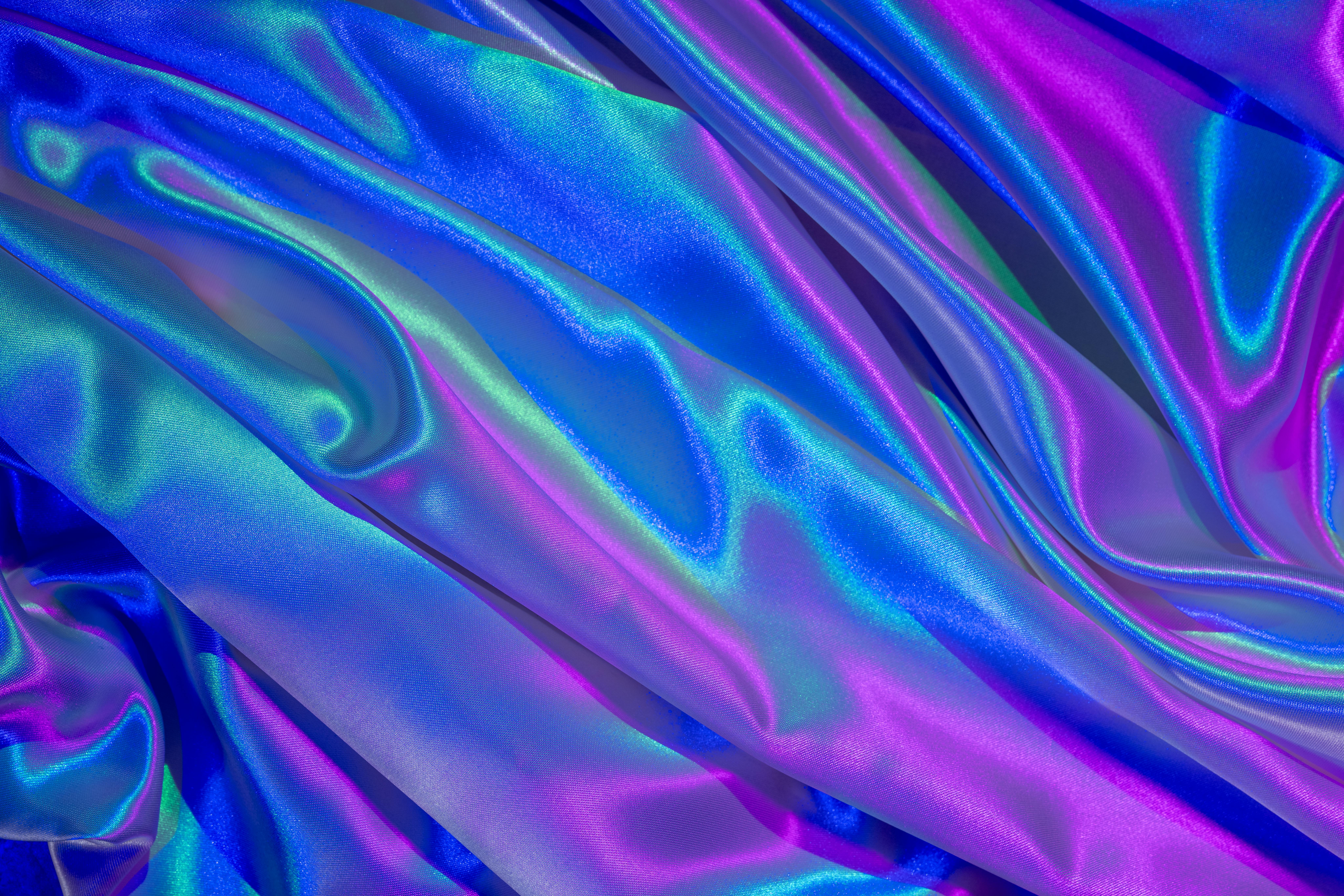 Gratis Primo piano di un vivace tessuto satinato nelle tonalità del blu e del viola, che mette in risalto un colorato effetto ondulato. Foto a disposizione