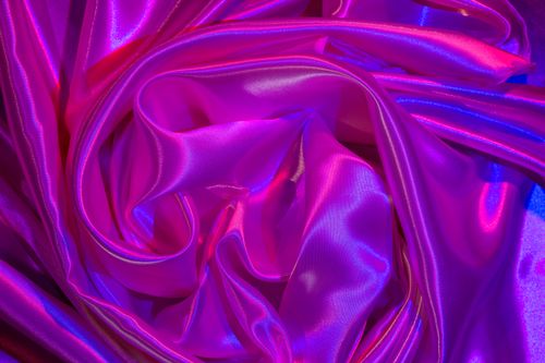 Free A vivid satin fabric in purple and pink hues showcases intricate folds and shimmering texture. Stock Photo
