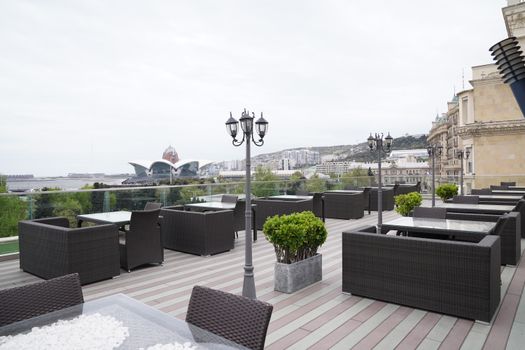 Spacious outdoor terrace with modern furniture and city landscape view. Ideal for leisure or business events.