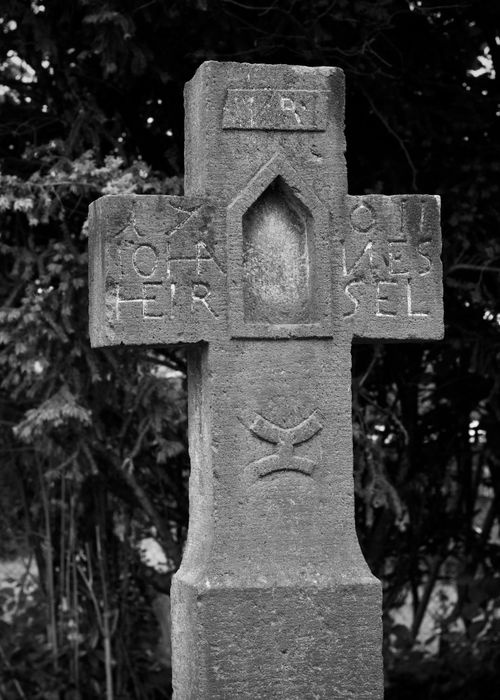 Free A black and white photo of an ancient stone cross with intricate carvings. Stock Photo