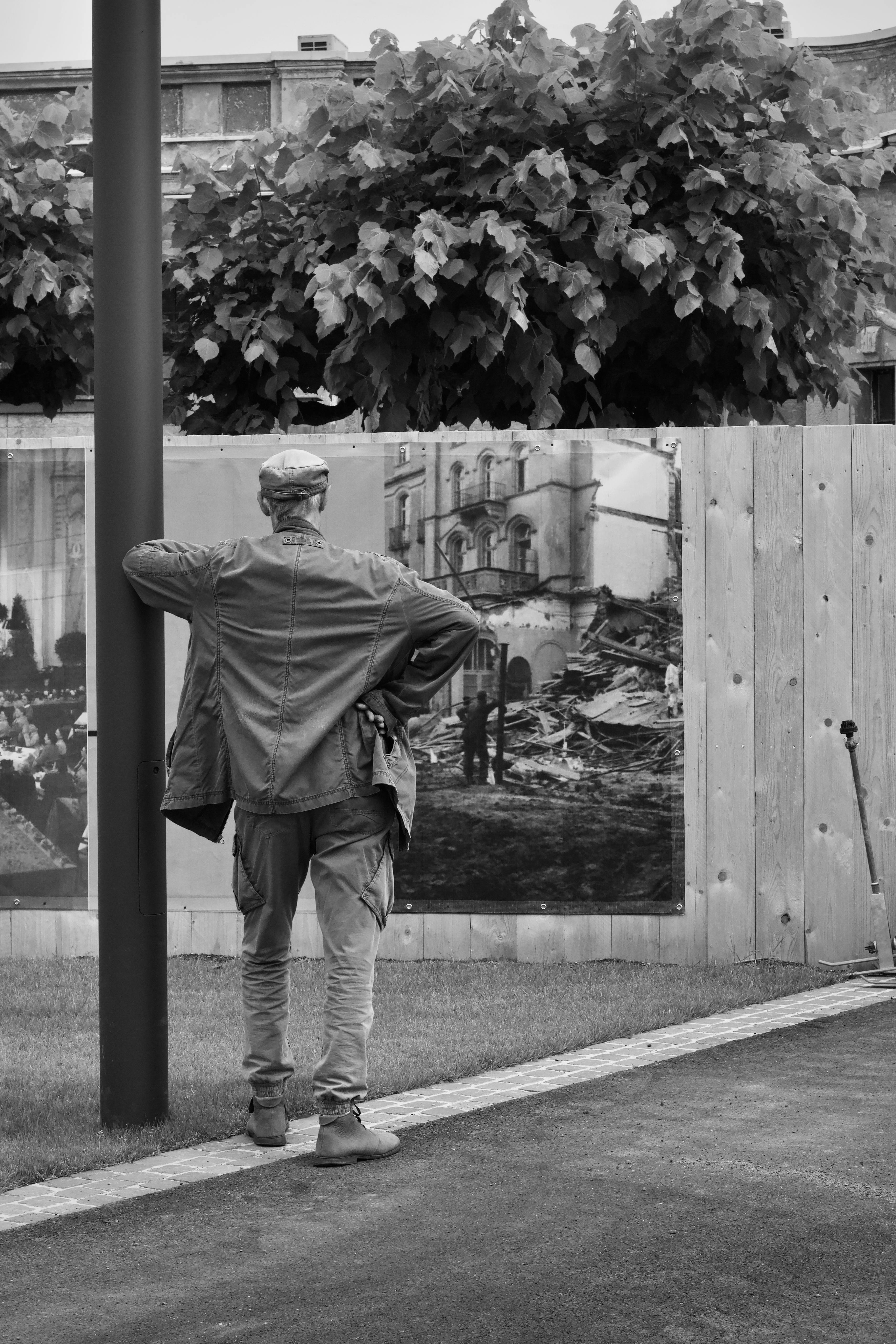 Free A man in a leather jacket studies outdoor black and white art pieces. Stock Photo