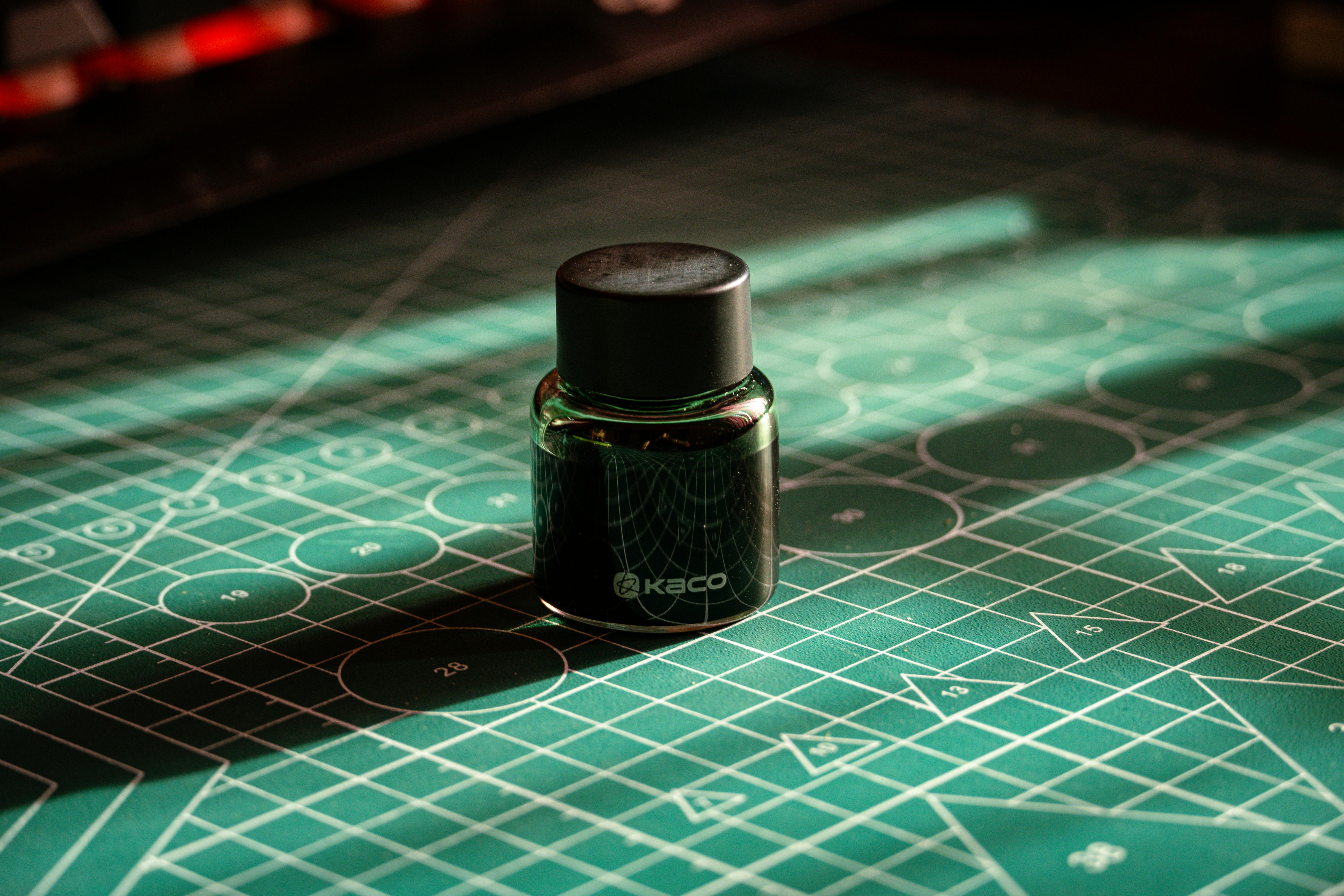 Miễn phí Một lọ mực đen trên tấm thảm cắt màu xanh lá cây tạo nên những bóng đổ nghệ thuật. Hoàn hảo cho hình ảnh không gian làm việc sáng tạo. Ảnh lưu trữ