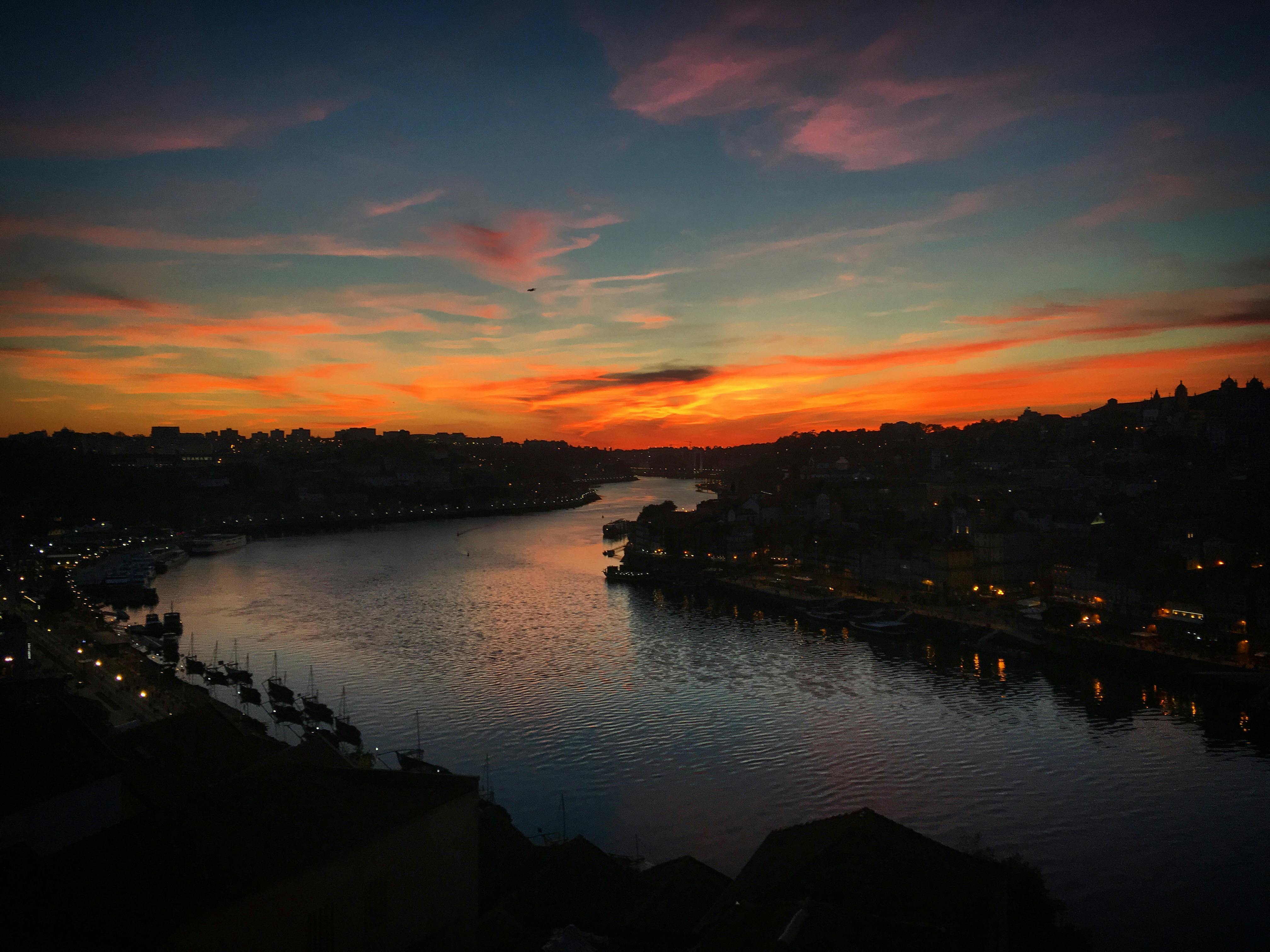 Stunning sunset view over the Douro River in Porto, reflecting vibrant colors in the water.