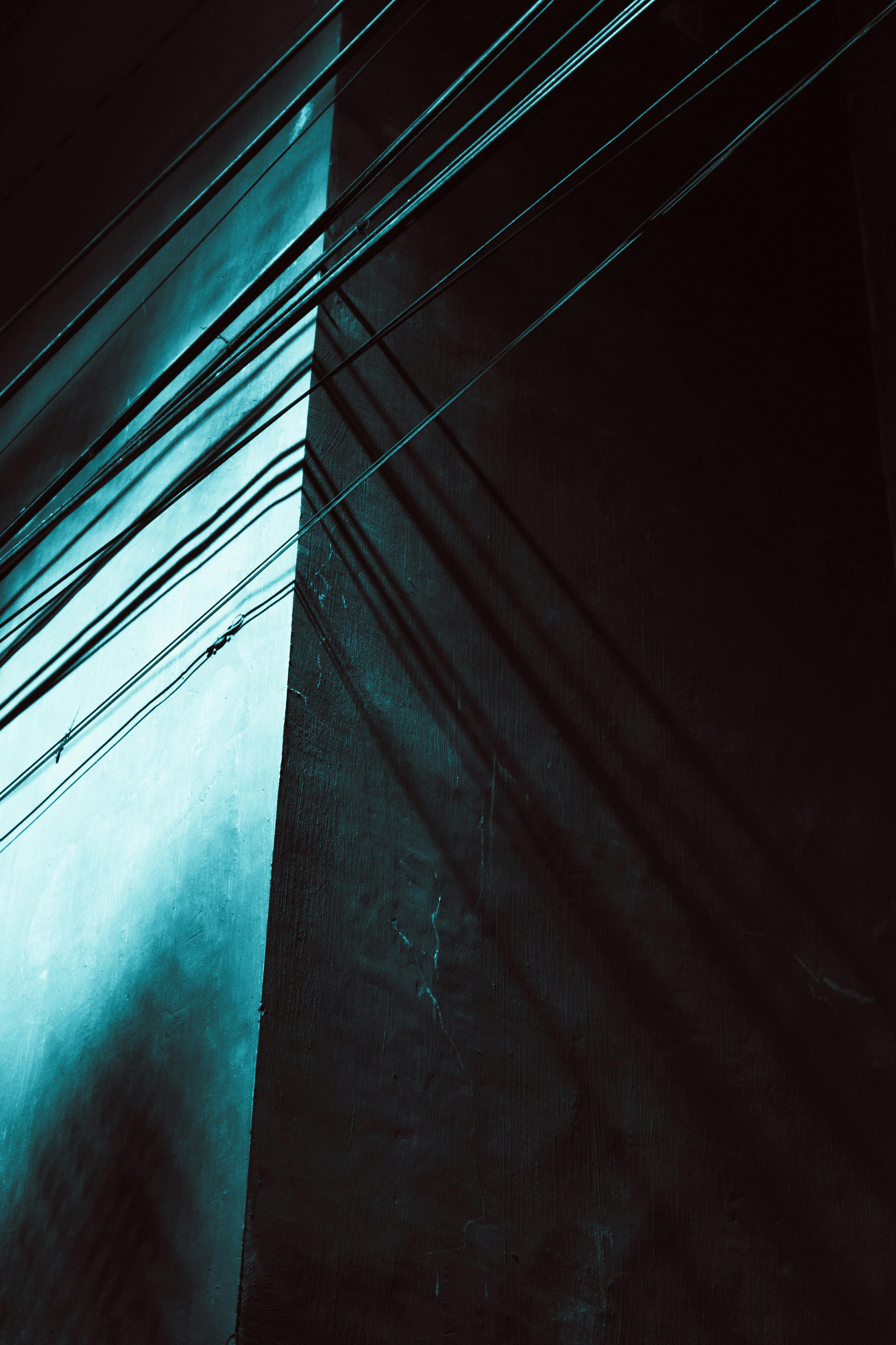 Gratis Una vista dramática de líneas de sombra en la fachada de un edificio que crean un patrón geométrico abstracto. Foto de stock