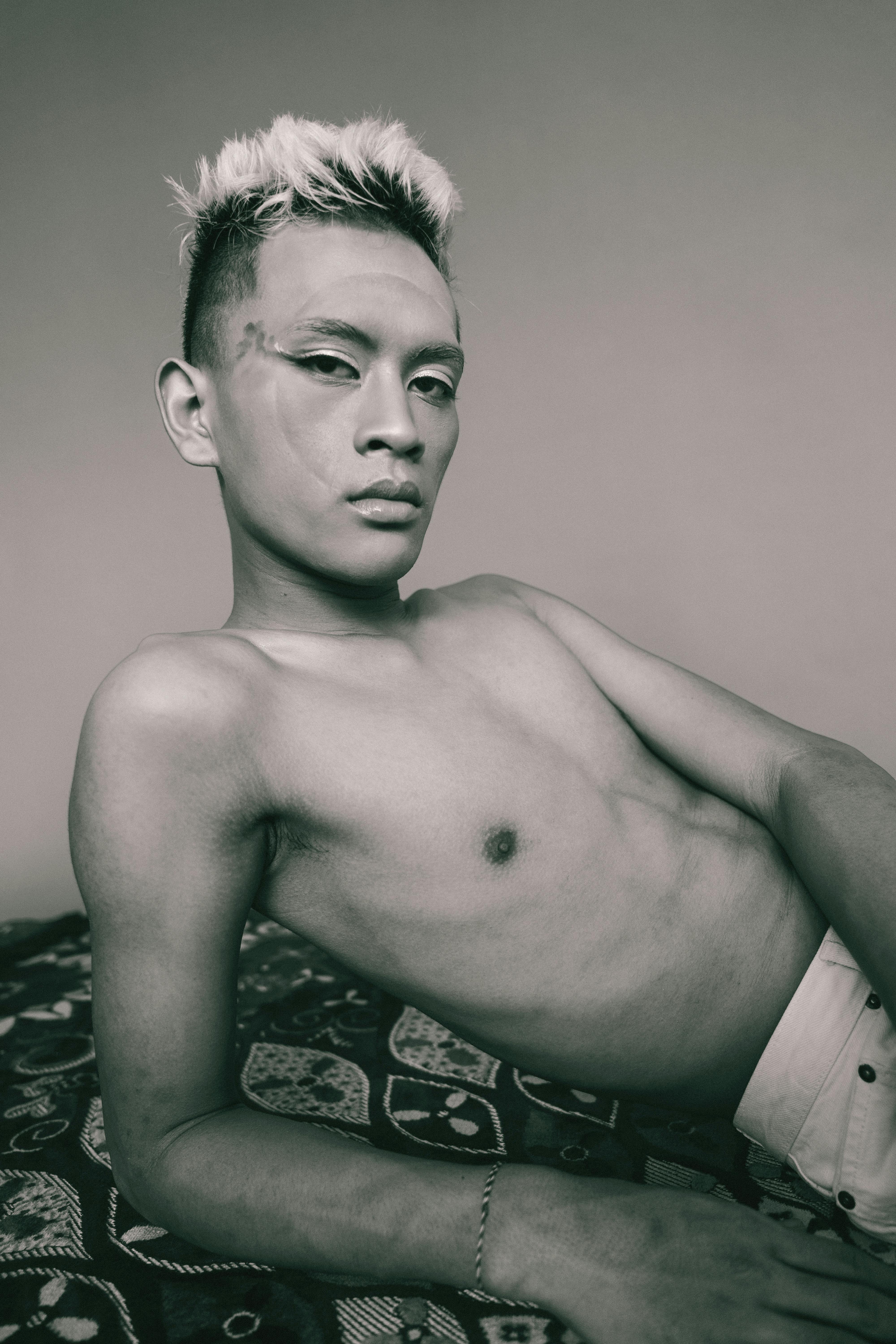 Ilmainen Taiteellinen mustavalkoinen muotokuva nuoresta miehestä poseeraa itsevarmasti sisätiloissa. Kuvapankkikuva