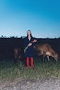 Woman with Red Roses and Cows at Twilight