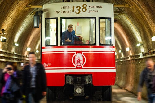 People Standing Beside Red and White Train