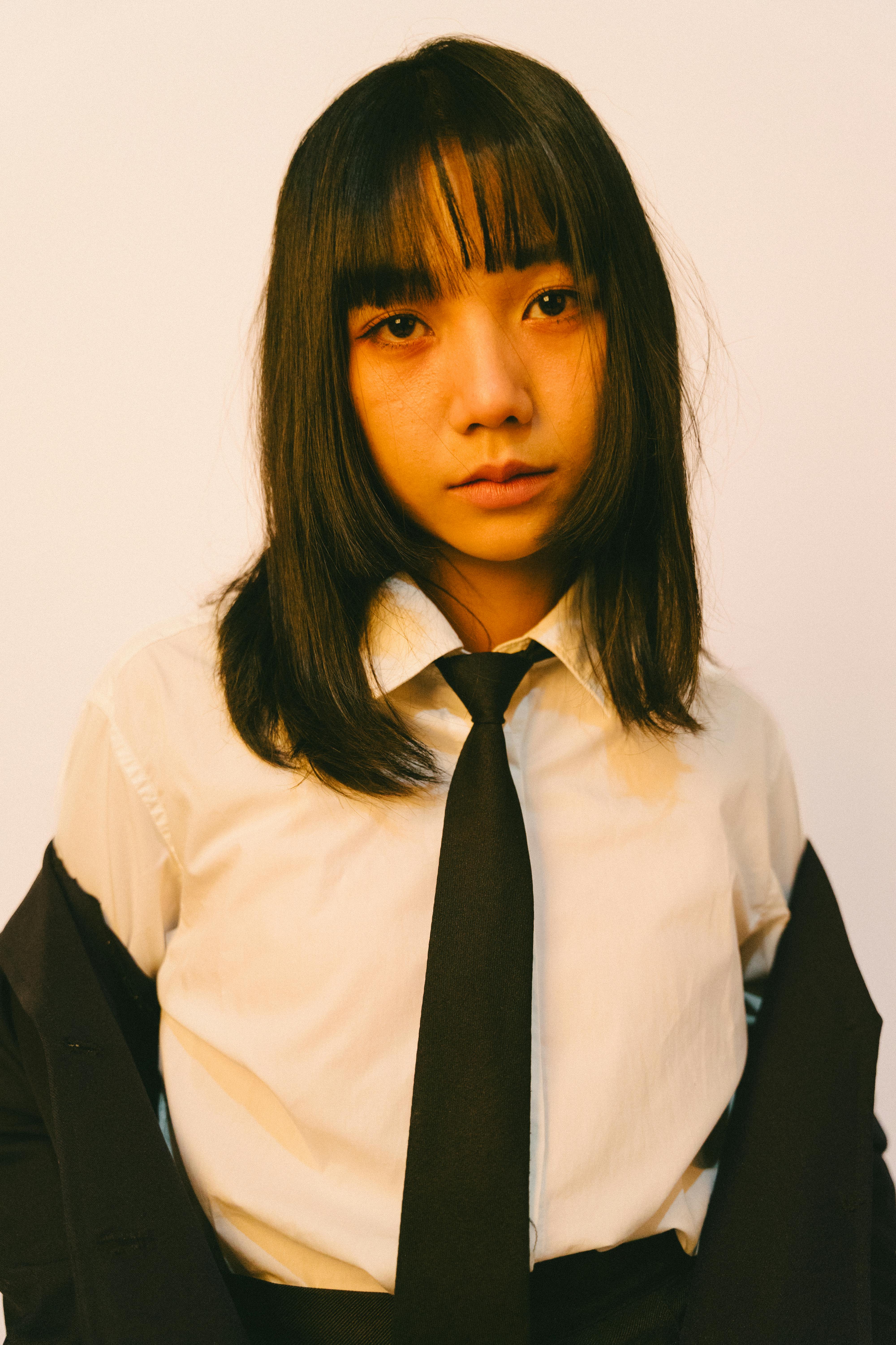 Miễn phí Một người trẻ tuổi trong trang phục lịch sự, nhìn thẳng vào máy ảnh với vẻ mặt không biểu cảm. Ảnh lưu trữ