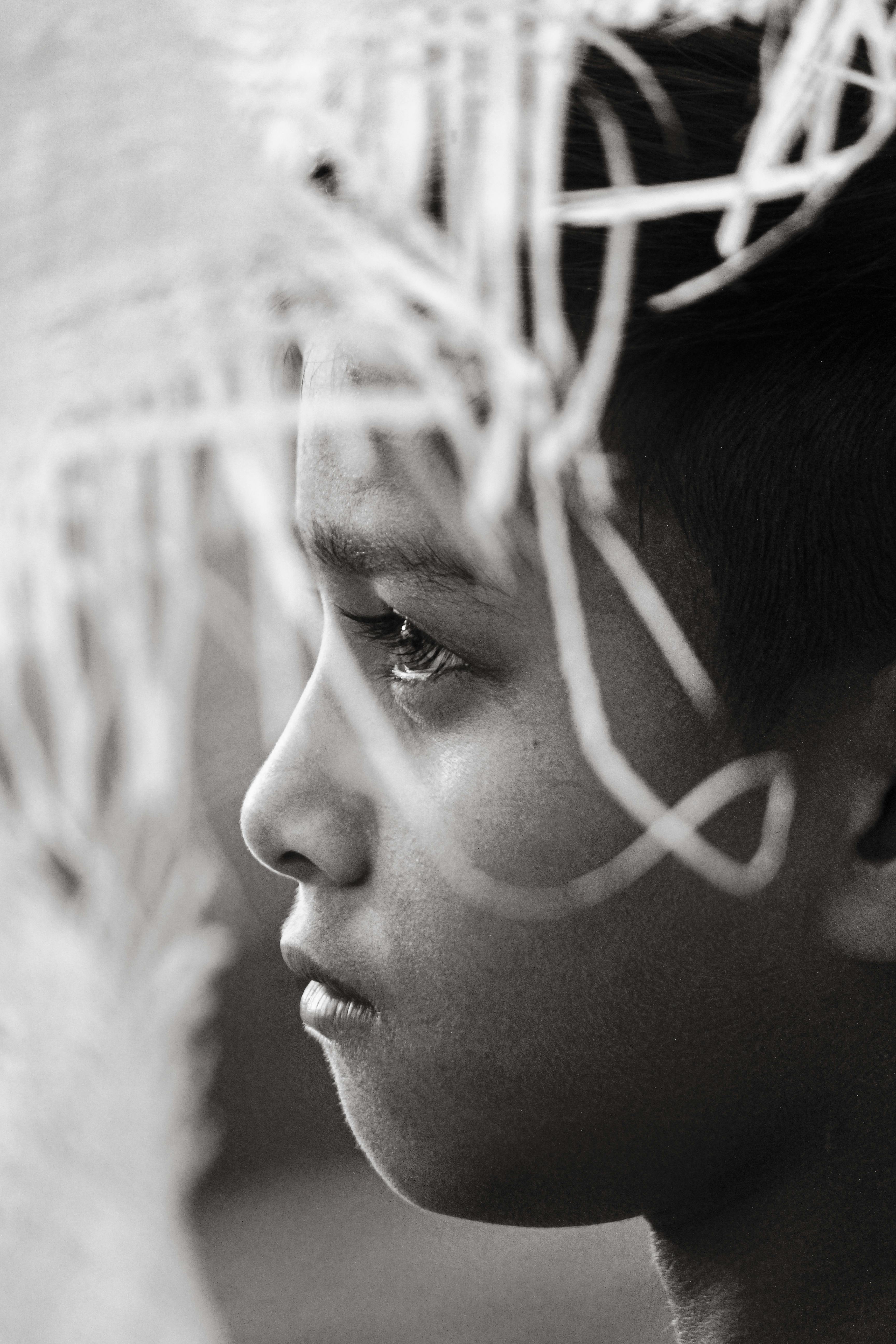 Ilmainen Tunteita herättävä mustavalkoinen profiilikuva lapsesta punotuin elementein. Kuvapankkikuva