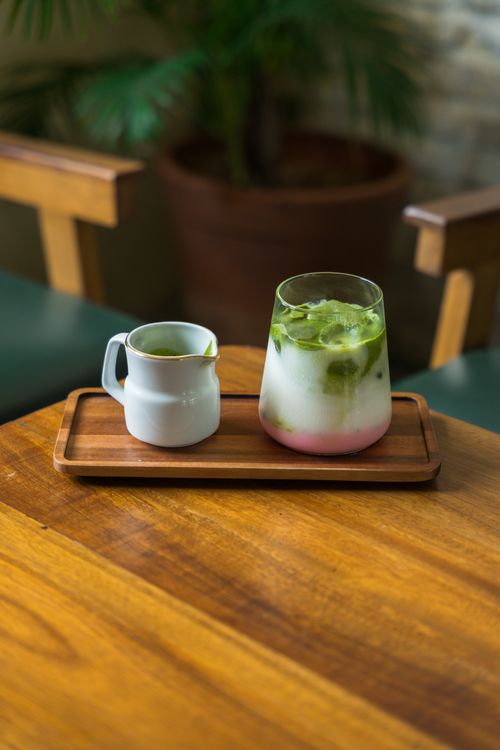 Free Vibrant matcha latte on a wooden tray, perfect for a cozy cafe atmosphere. Stock Photo
