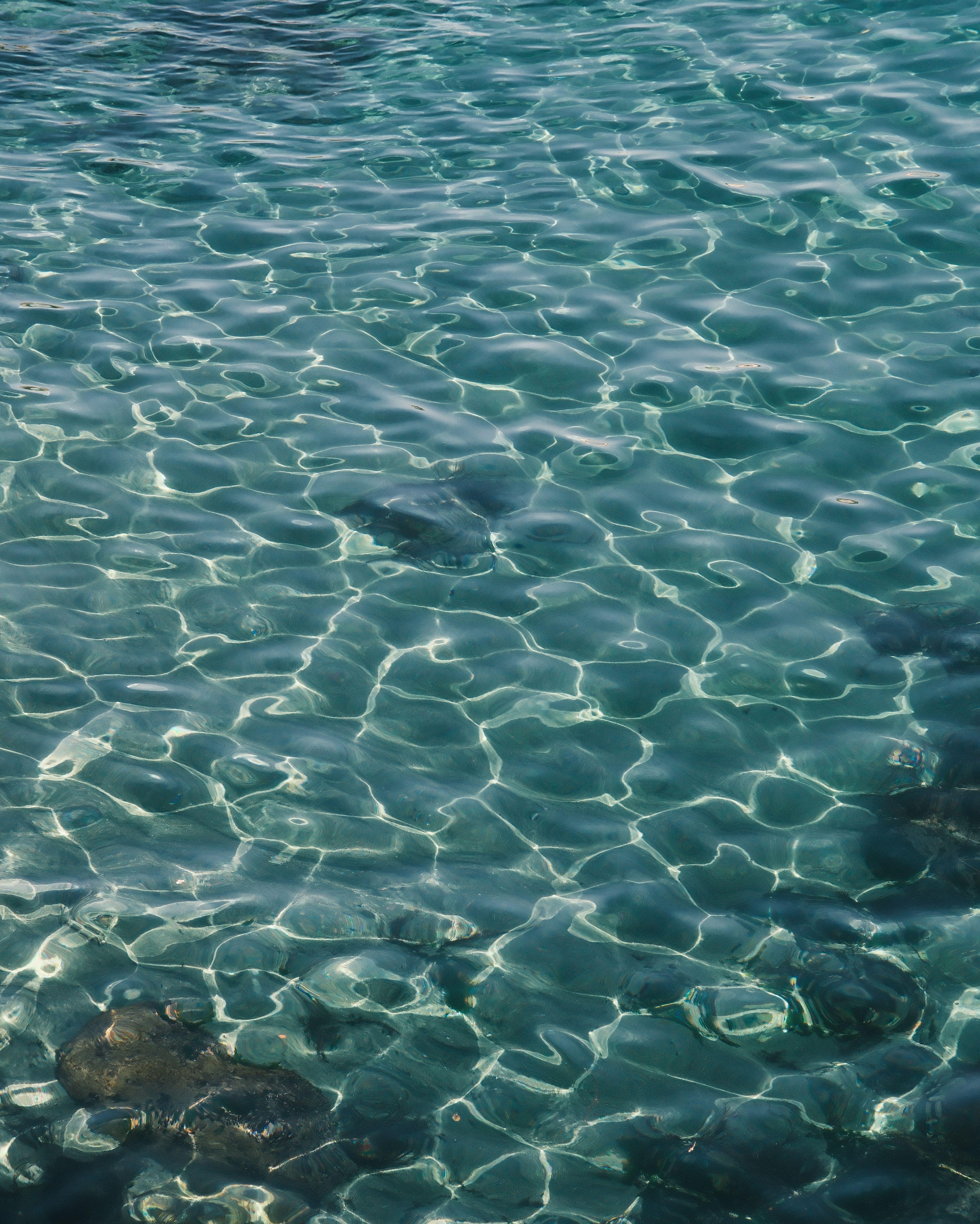 Captivating view of clear Aegean Sea water reflecting sunlight in Amasra, Türkiye.