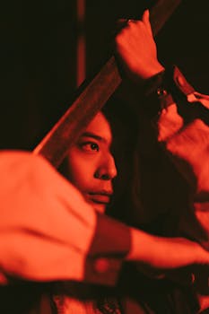 Artistic portrait of a person illuminated by red lighting, creating a dramatic atmosphere.