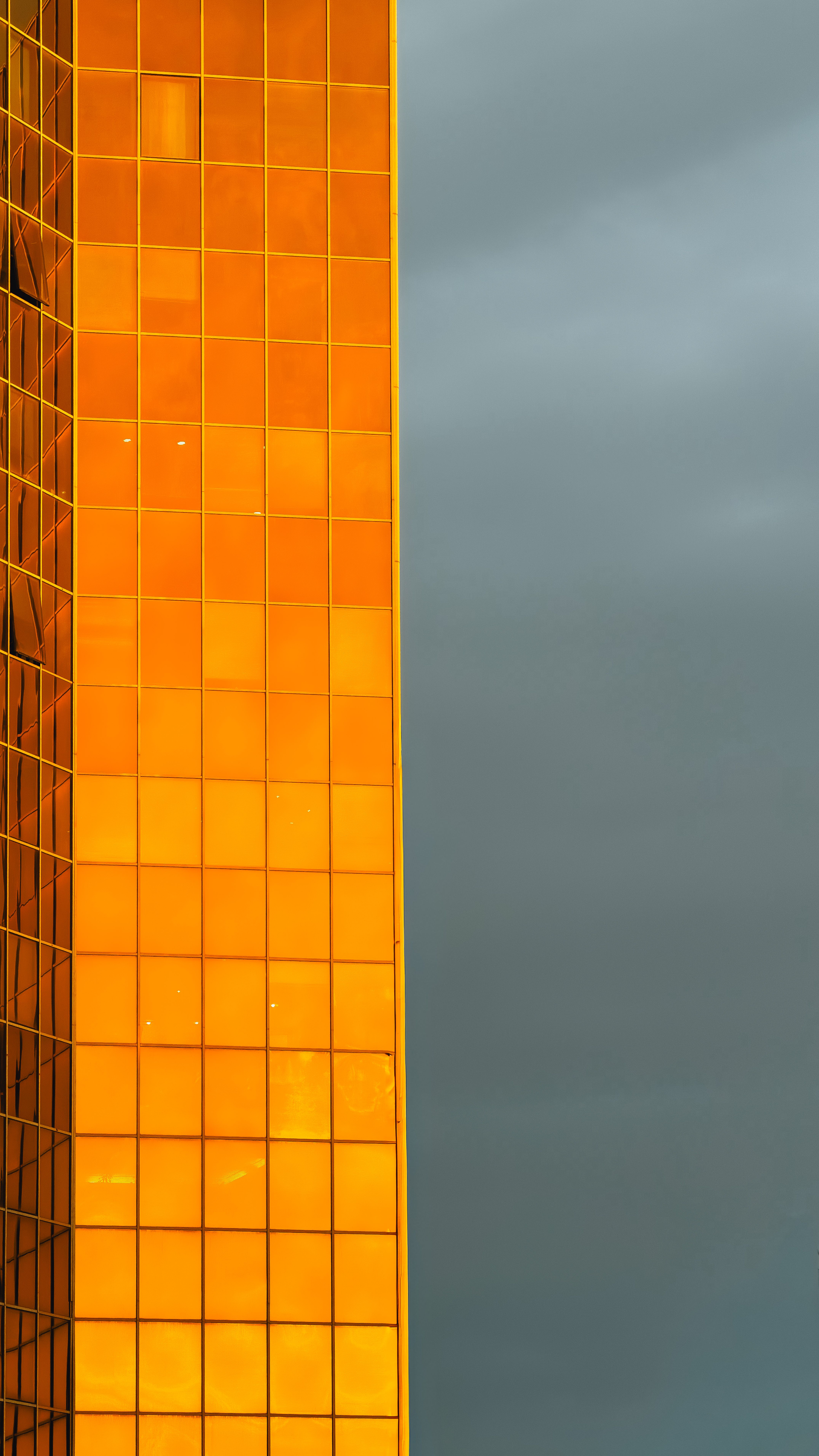 Golden Glass Facade Against Dramatic Sky · Free Stock Photo