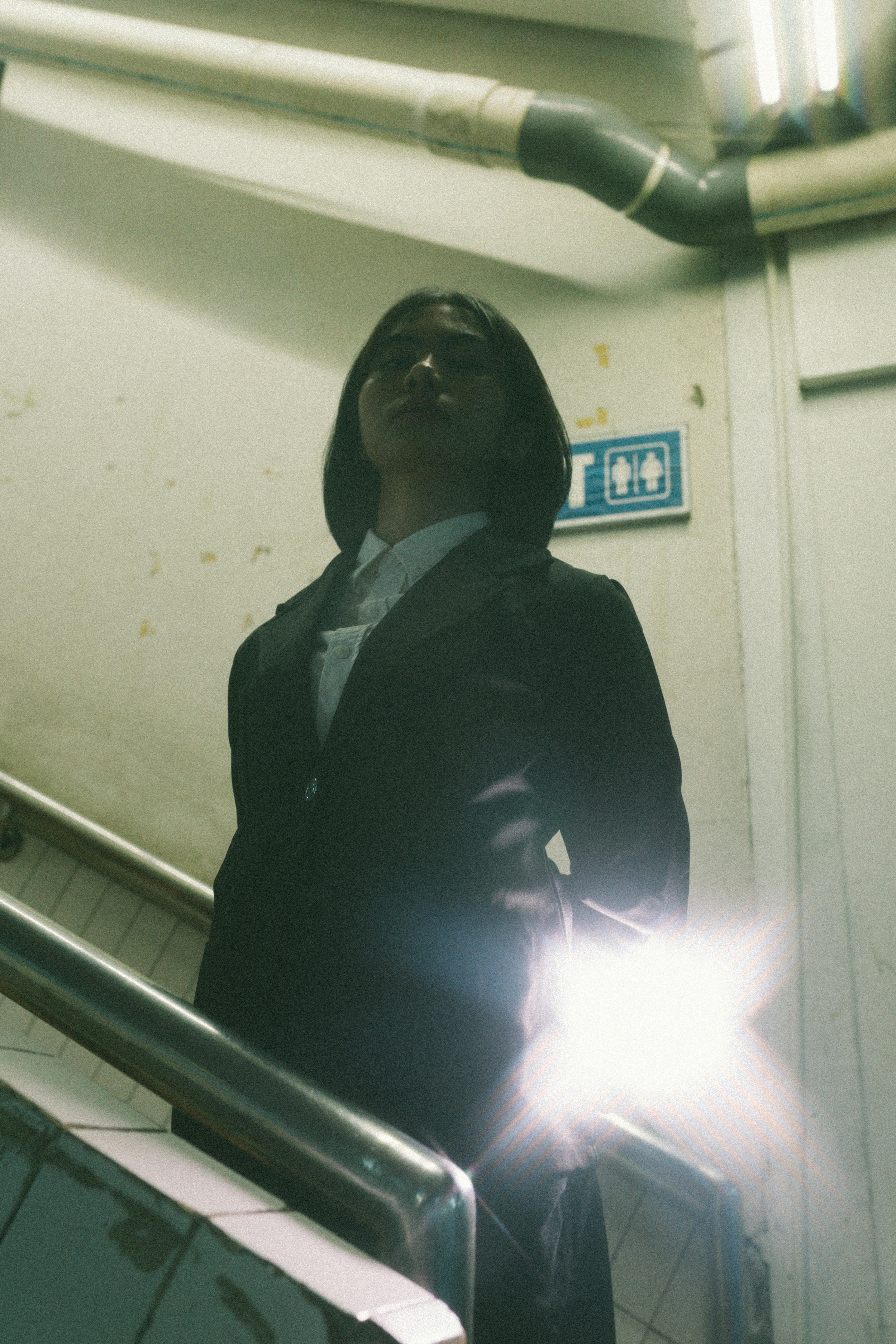 Miễn phí Một người phụ nữ trong trang phục trang trọng đứng đầy vẻ trang trọng trong cầu thang thiếu ánh sáng. Ảnh lưu trữ