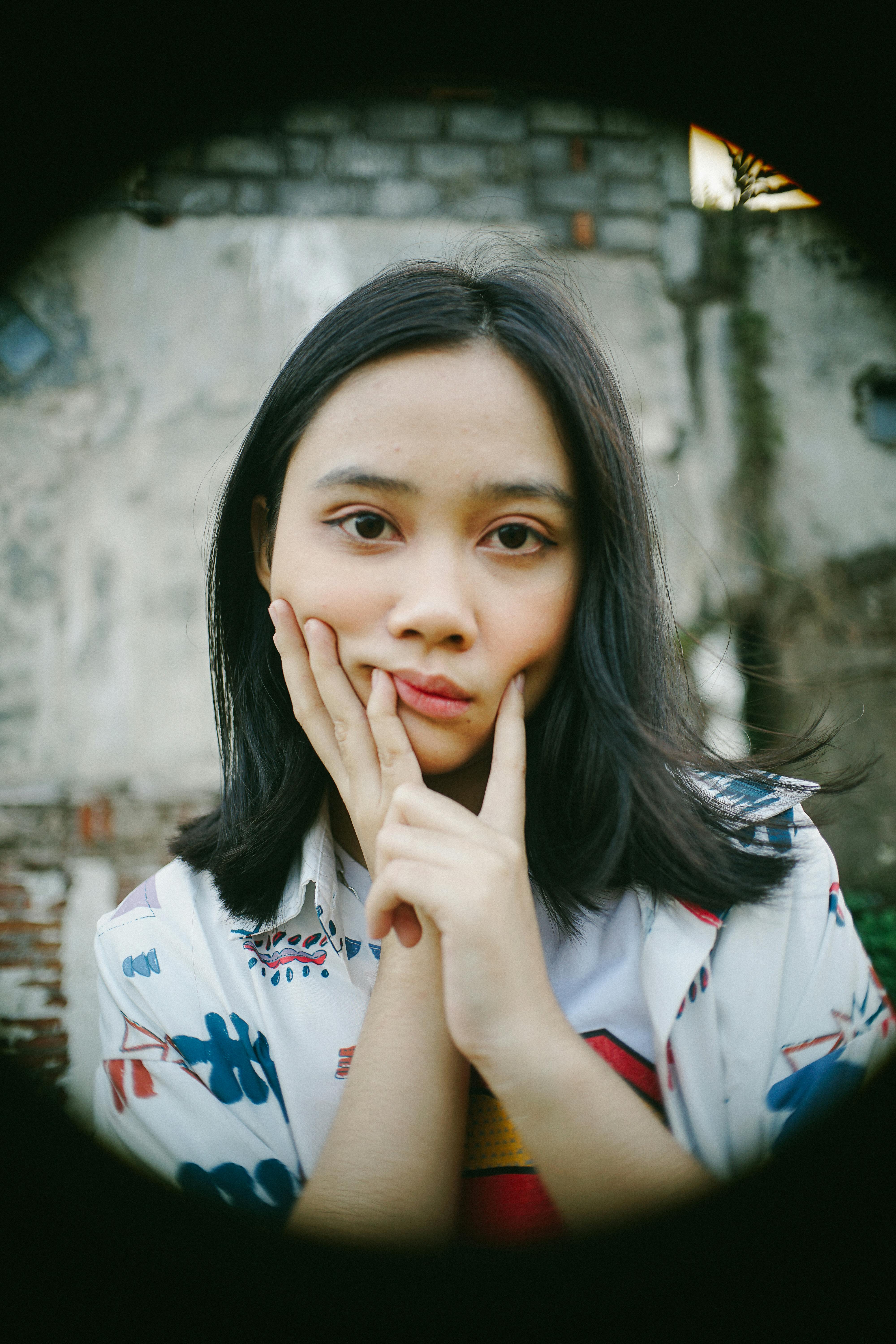 bezplatná Portrét zamyšlené mladé ženy venku s kontemplativním výrazem. Základová fotografie