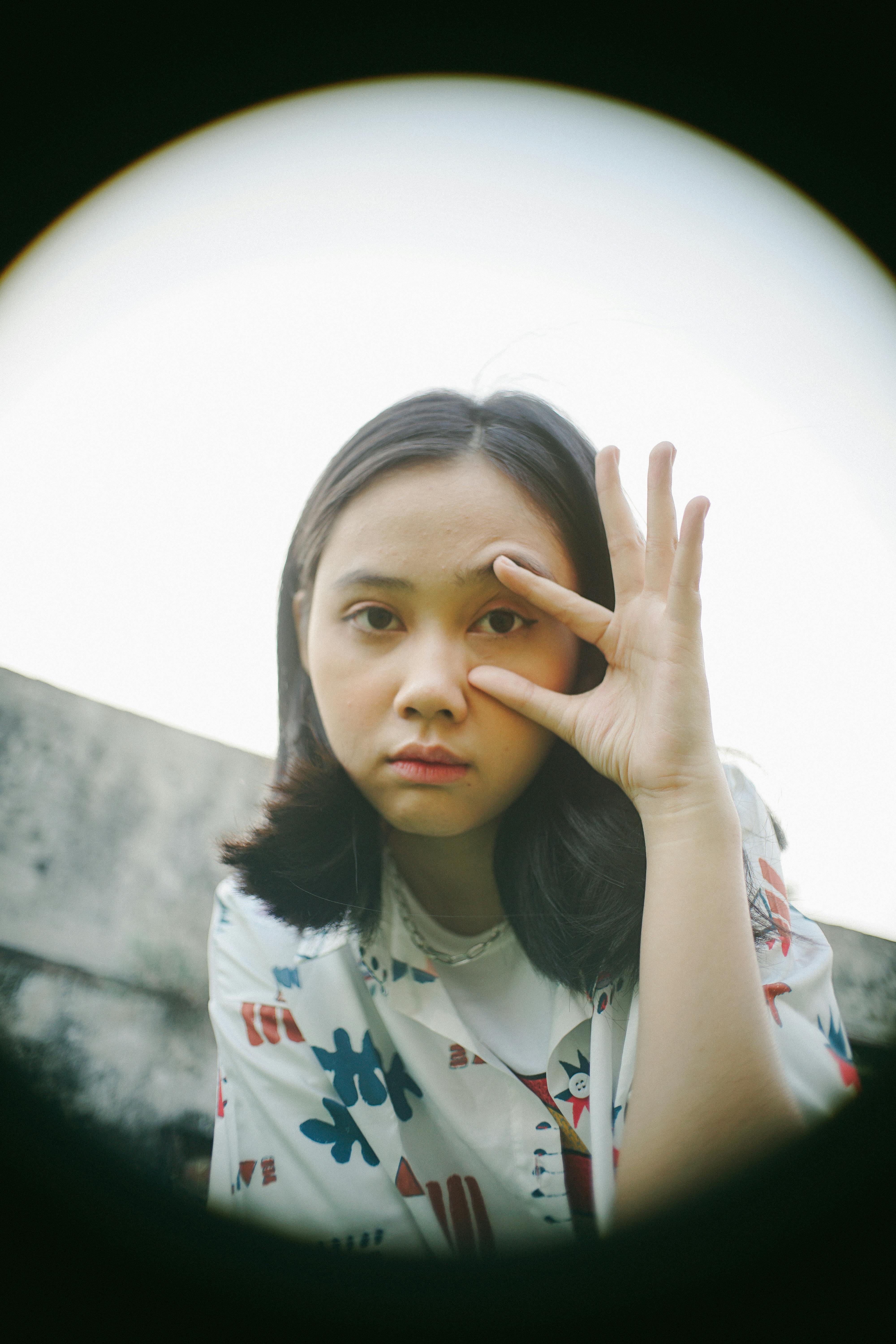 Ücretsiz Düşünceli bir pozda, elini gözünün yanına koymuş genç bir kadının sanatsal portresi. Stok Fotoğraflar