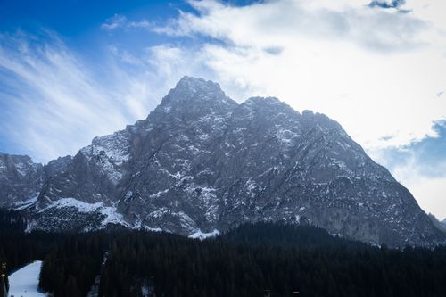 Free Stunning snow-covered mountain peaks rise under a bright, cloudy sky. Stock Photo