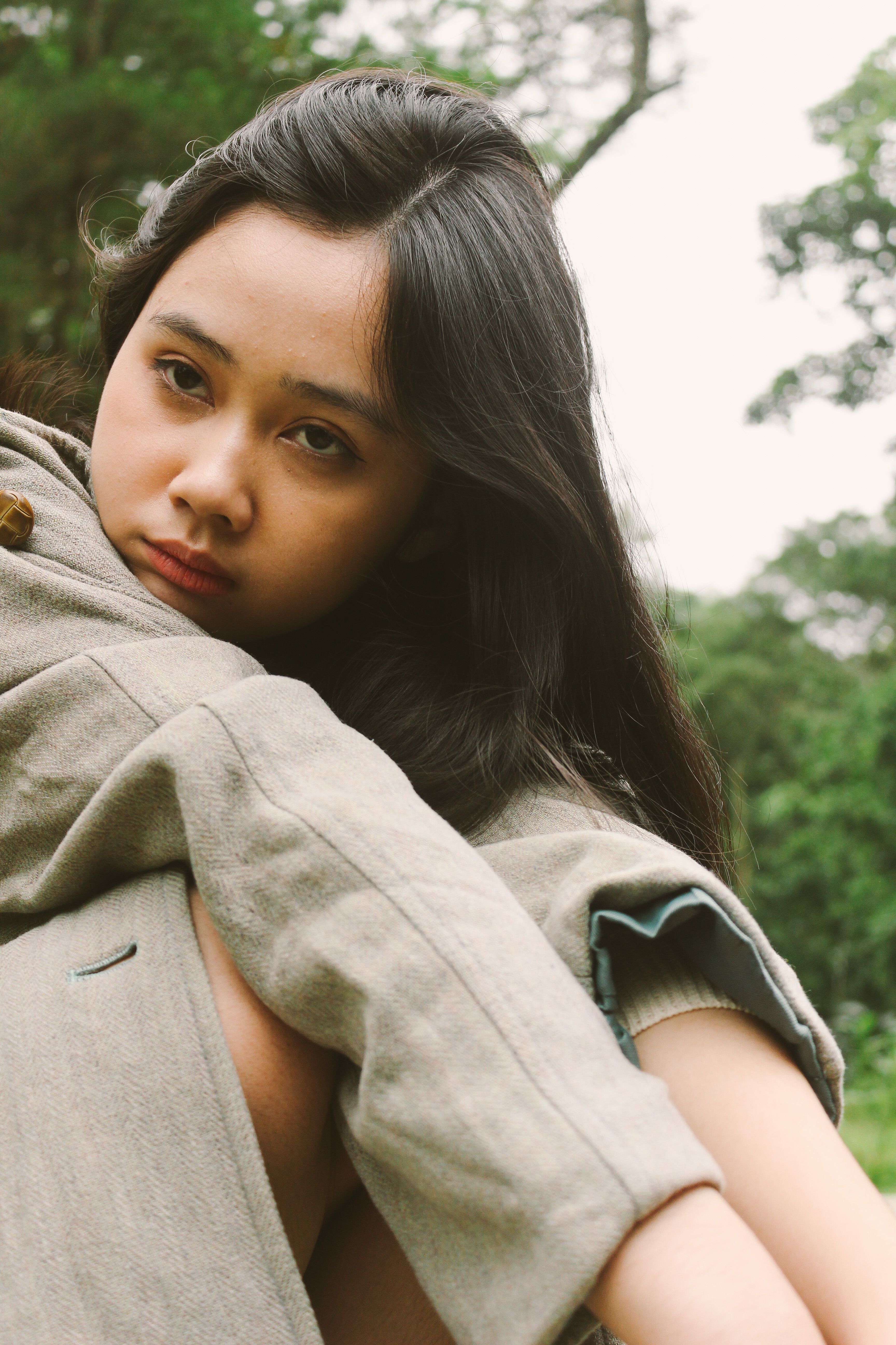 Pensive Young Woman Outdoors in a Park Setting