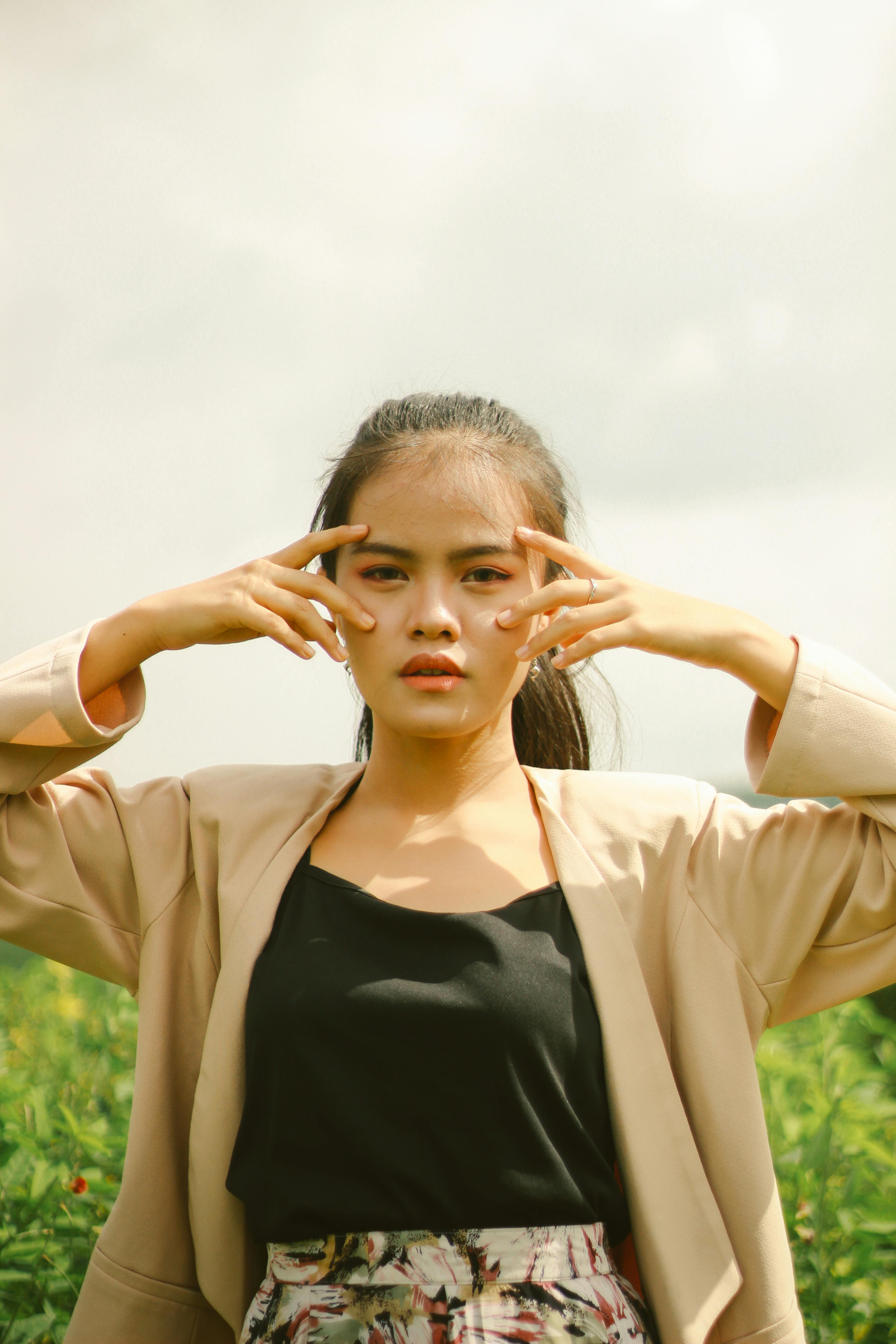 gratis Portret van een jonge vrouw die creatief poseert in een buitenomgeving en zelfvertrouwen uitstraalt. Stockfoto