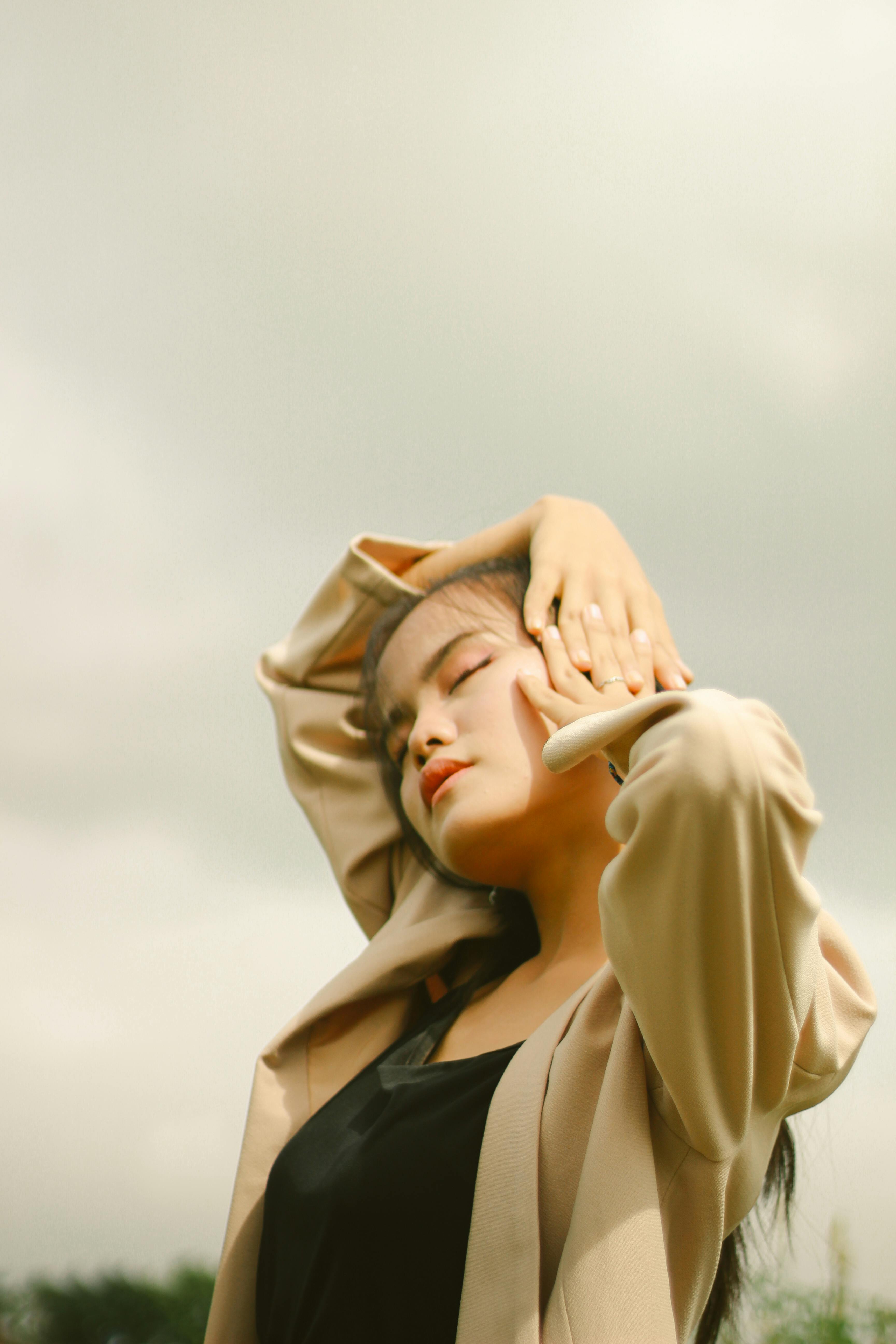 Miễn phí Một người phụ nữ sành điệu tạo dáng ngoài trời, đón nhận thời tiết nhiều mây với vẻ thanh lịch và duyên dáng. Ảnh lưu trữ