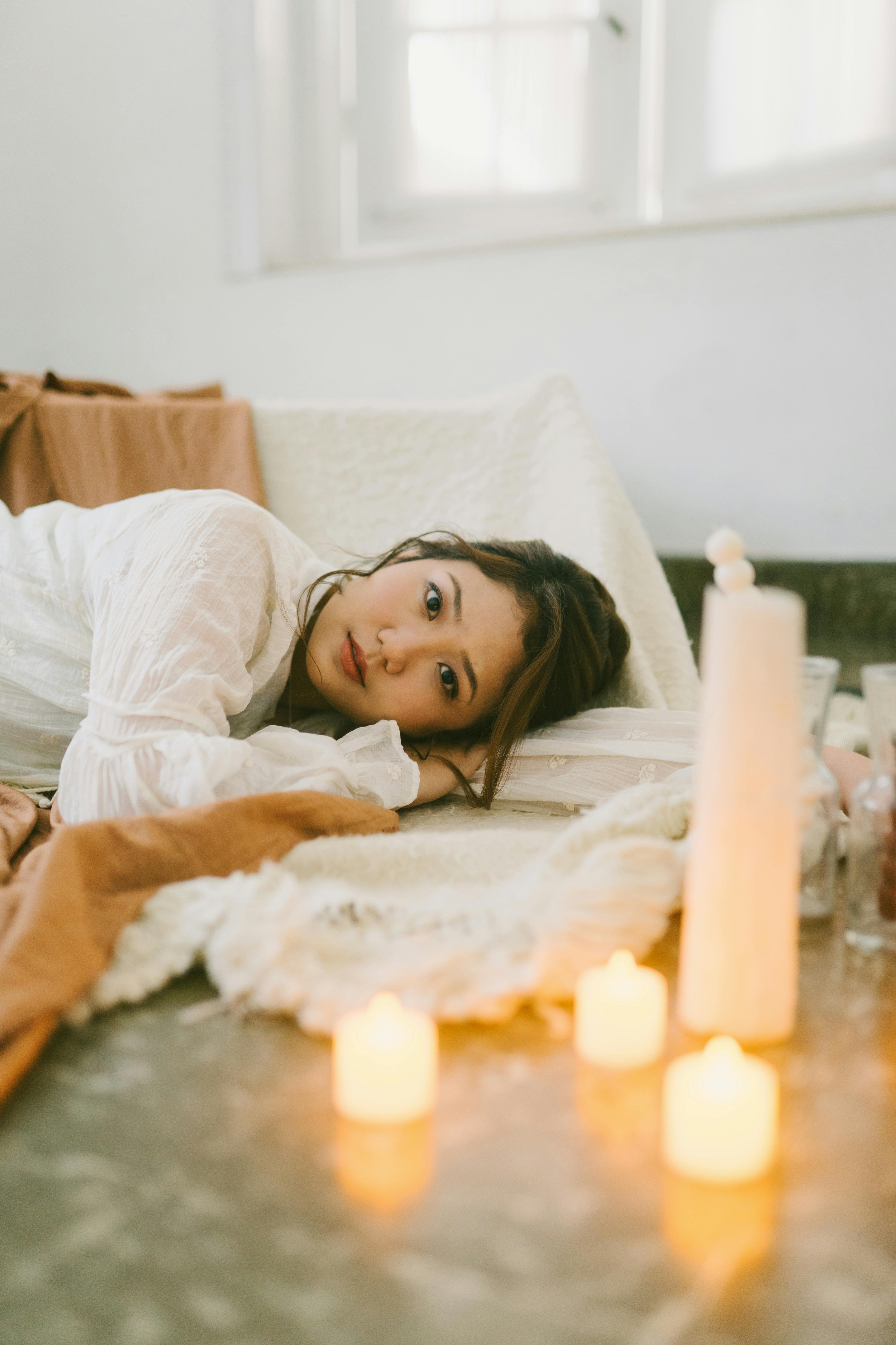 Cozy candlelit room with relaxed woman, warm intimate ambiance