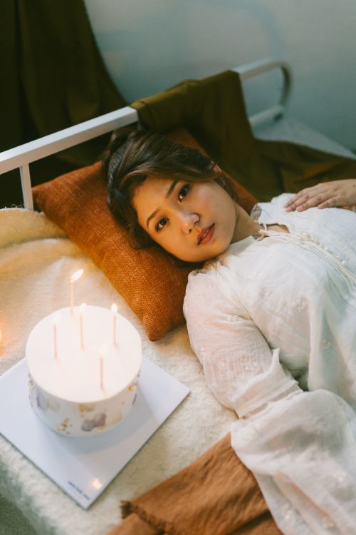 Free Young woman relaxing in soft lighting with a candle-lit atmosphere, creating a tranquil mood. Stock Photo