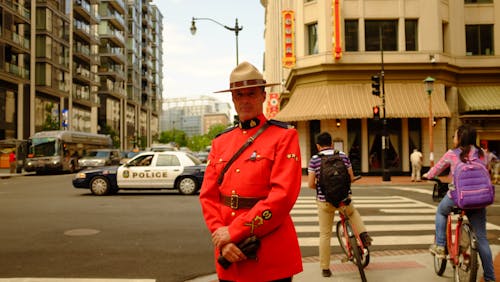 Man in Uniform Standing on Sidewalk